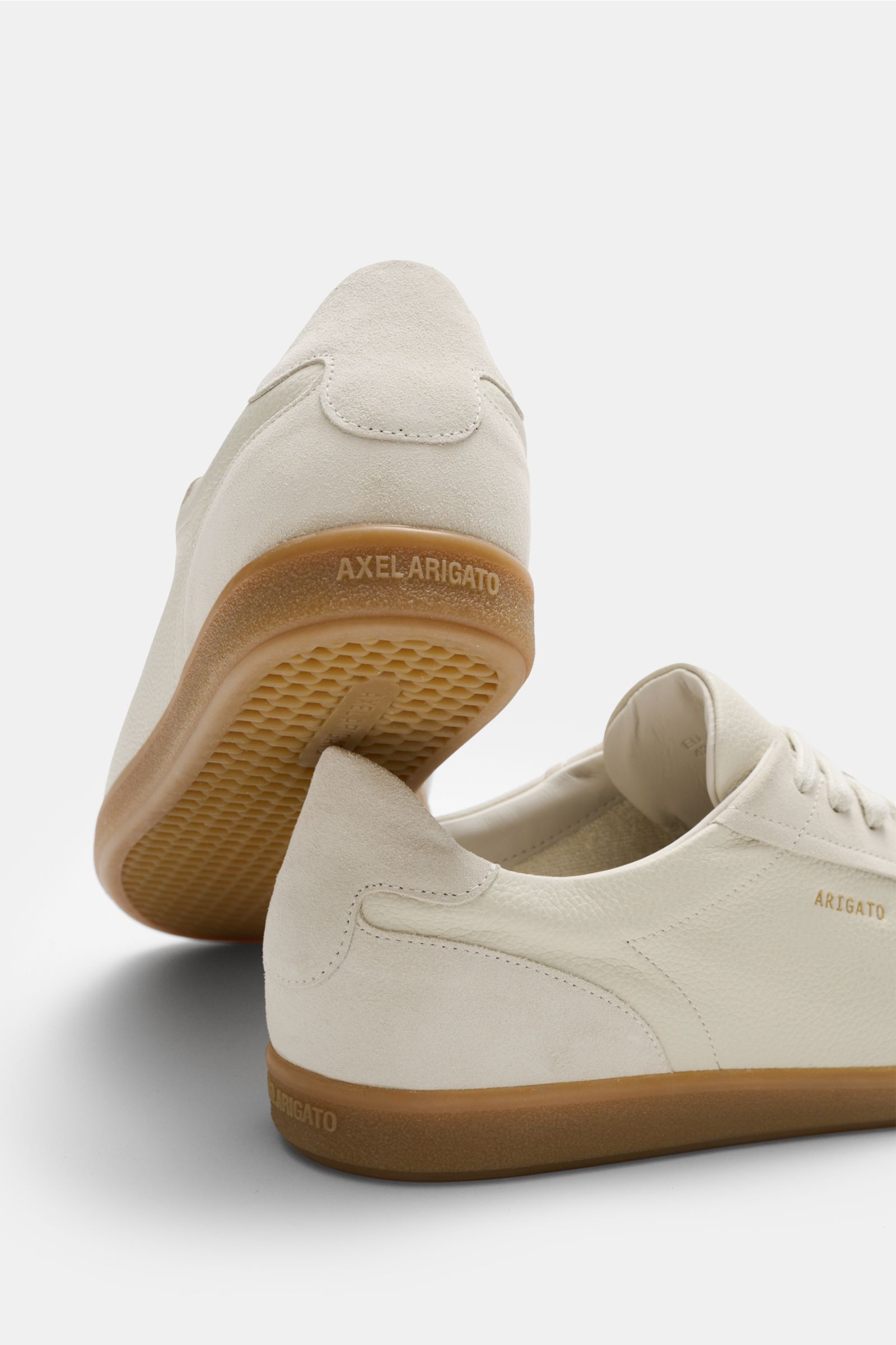 Rear and side view of Axel Arigato Sneaker 'Zane' creme in finely grained leather with suede overlays, rubber sole, and gold logo. 
