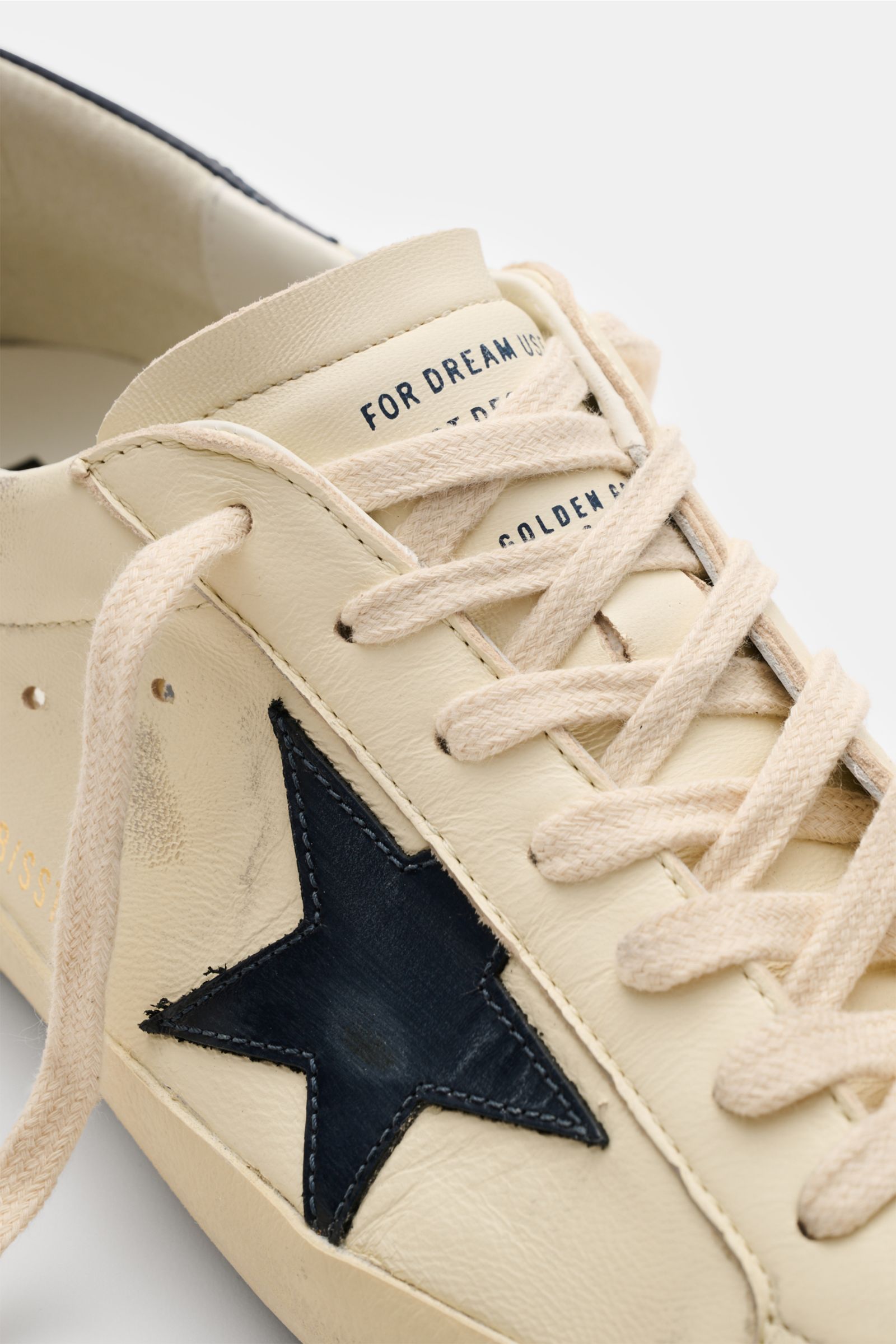 Golden Goose Sneaker 'Super-Star Classic' creme/navy, Nahaufnahme von vorne schräg oben, Vintage-Finish, Nappaleder, navy Stern, Used-Optik, Sieben-Loch-Schnürung, gepolsterter Schaftrand.