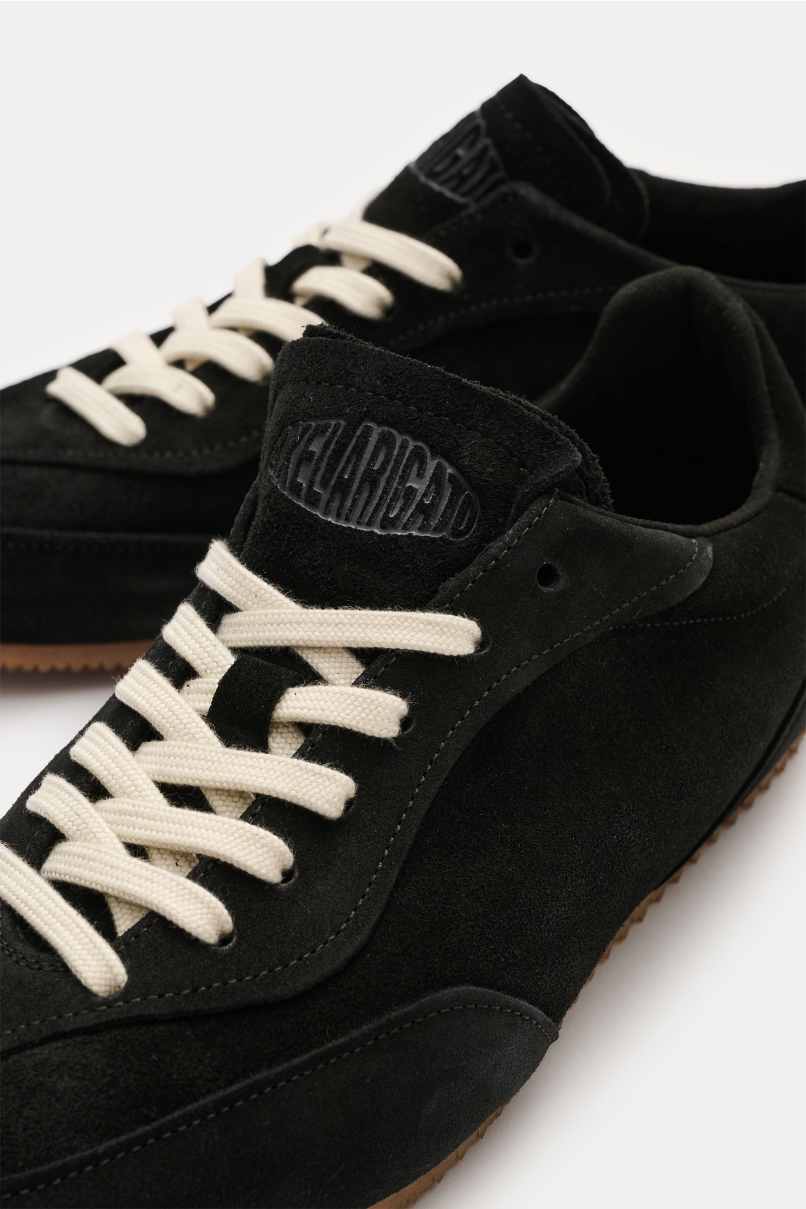 Nahaufnahme des Axel Arigato Sneaker 'Daze Runner' schwarz aus Veloursleder mit tonalen Overlays, gepolstertem Schaftrand und flexibler Gummisohle, von oben schräg fotografiert.