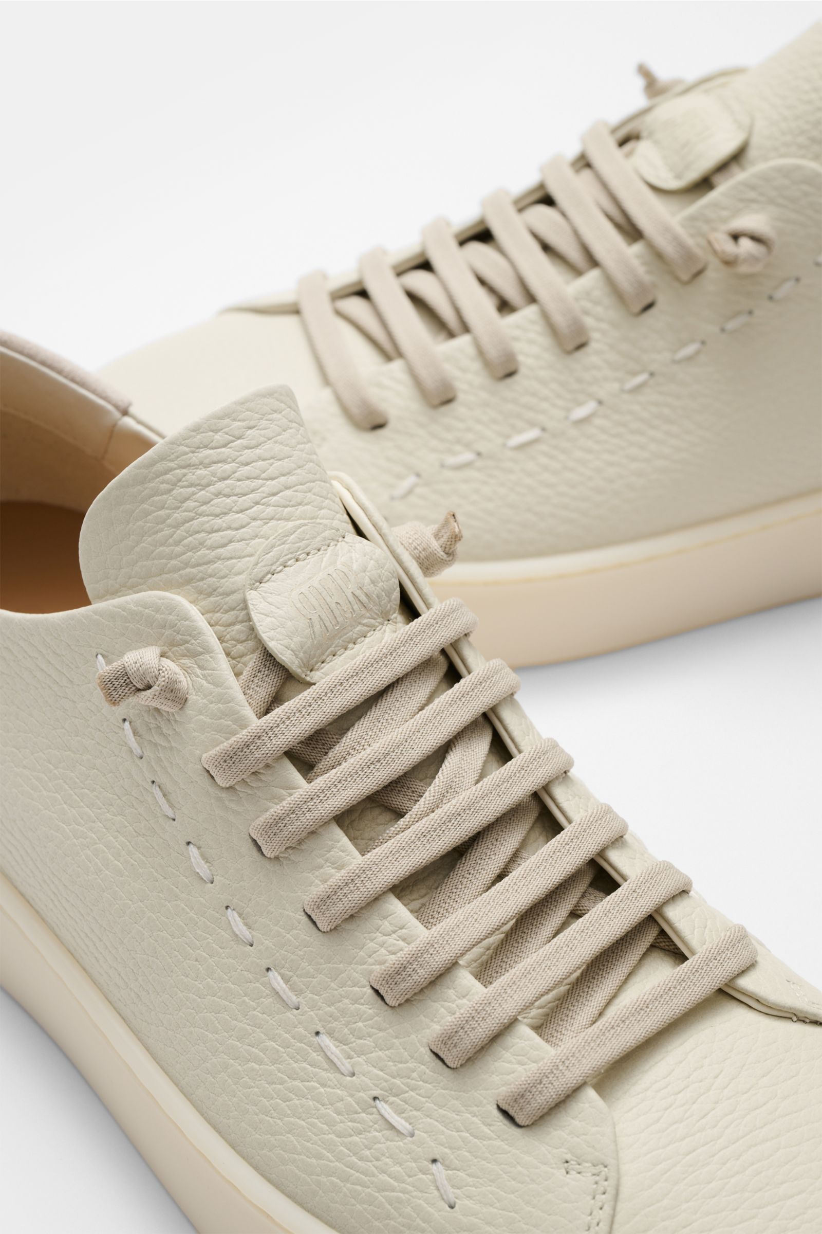 Fabiano Ricci Sneaker creme aus weichem, strukturiertem Nappaleder mit elastischer Sieben-Loch-Schnürung, Nahaufnahme von oben.