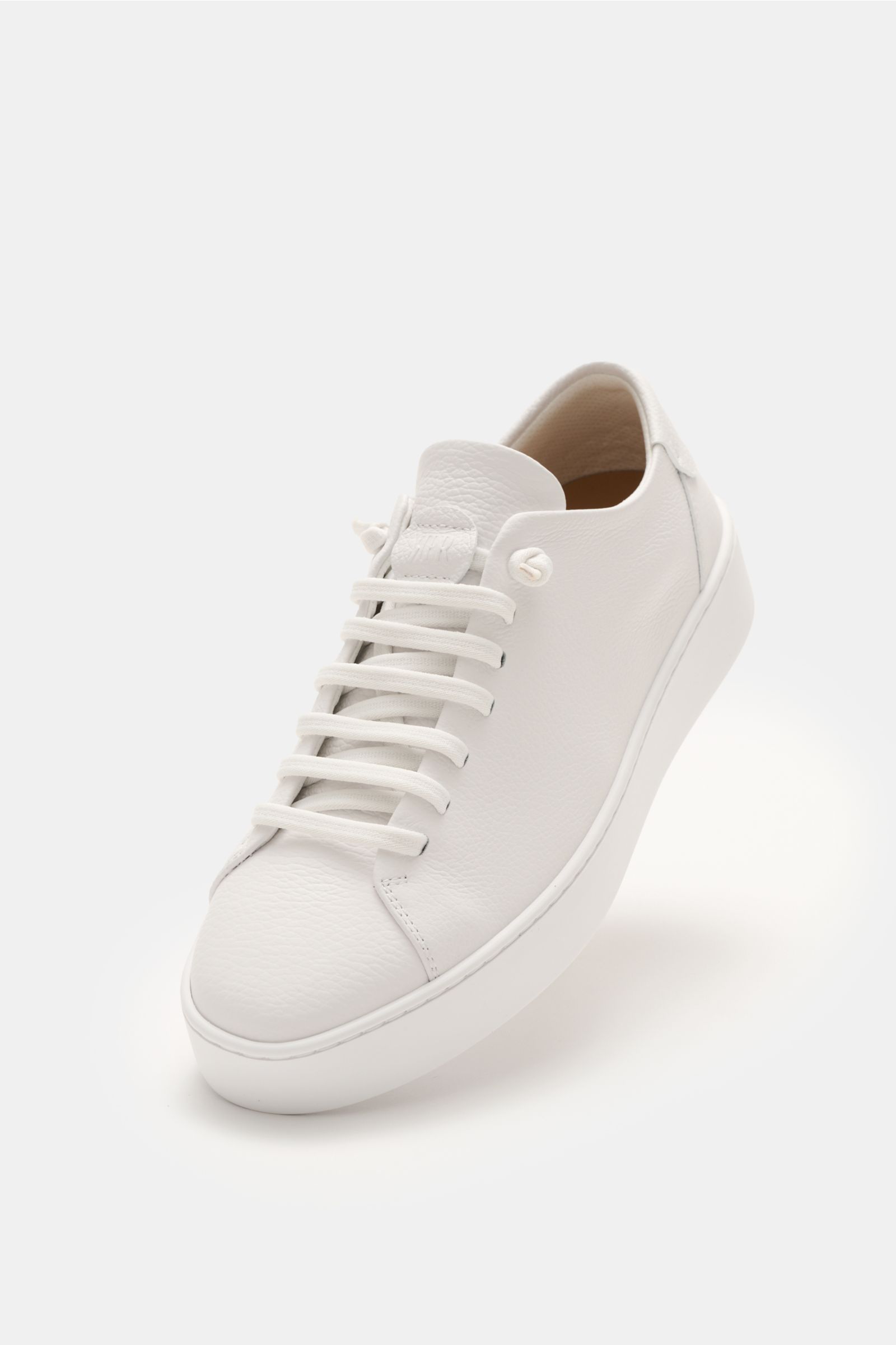 Front-side view of the Fabiano Ricci Sneaker weiß in soft, grained white Nappa leather, featuring seven-hole elastic lacing for a slip-on effect, round toe, logo-embossed tongue, mesh lining, removable padded insole, and flexible rubber sole.
