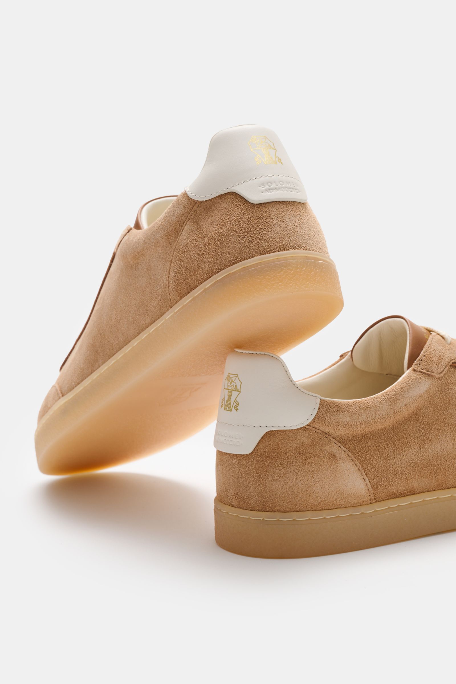 Brunello Cucinelli Sneaker hellbraun aus Veloursleder, schmal zulaufend, mit weißer Fersenkappe, Naturgummi-Sohle, Rückansicht leicht von unten.