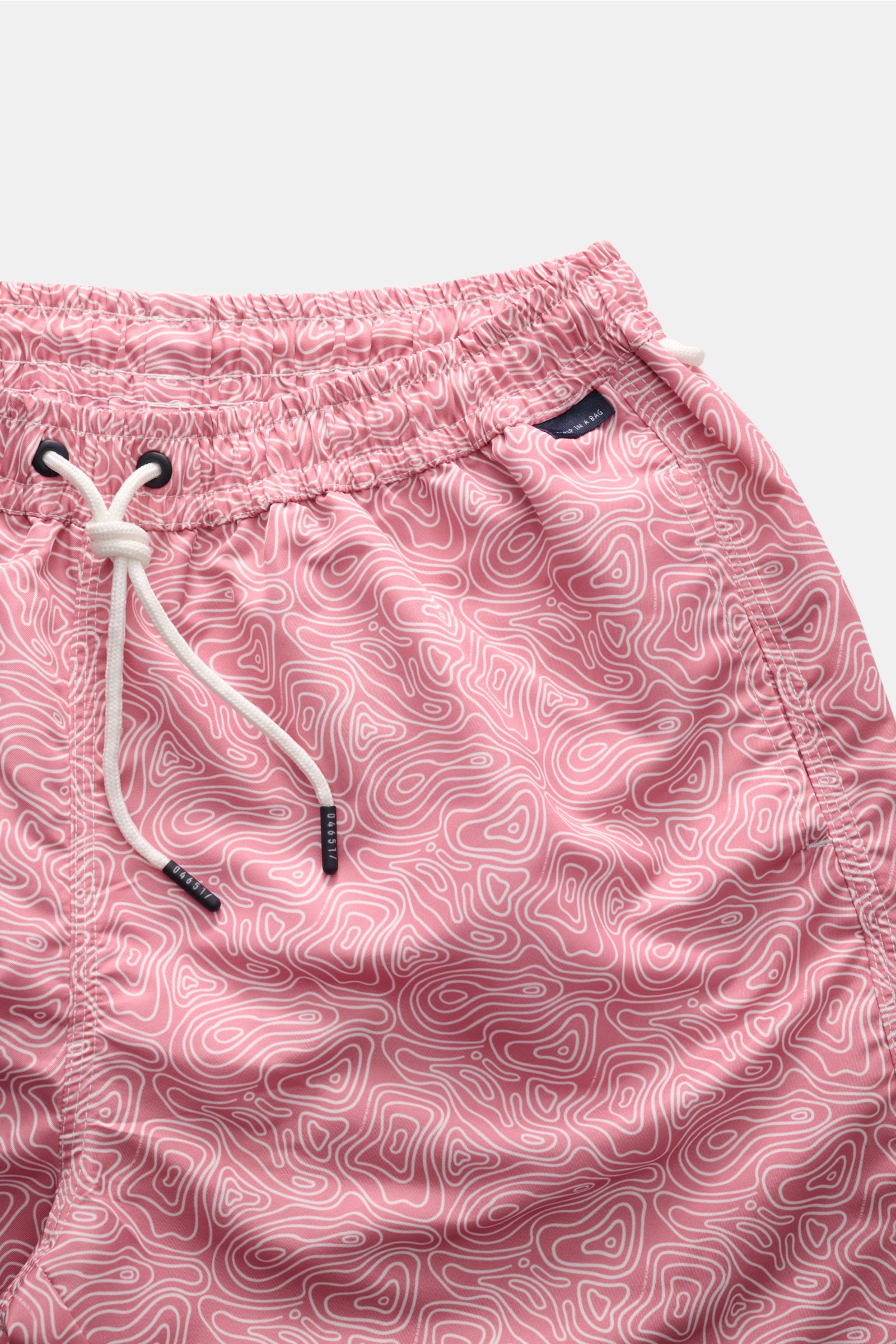 Close-up front view of 04651/ A trip in a bag Badeshorts 'Seamap' hellrot/weiß gemustert made of quick-drying microfiber with elastic waistband, drawstring, side pockets, and nautical map pattern.