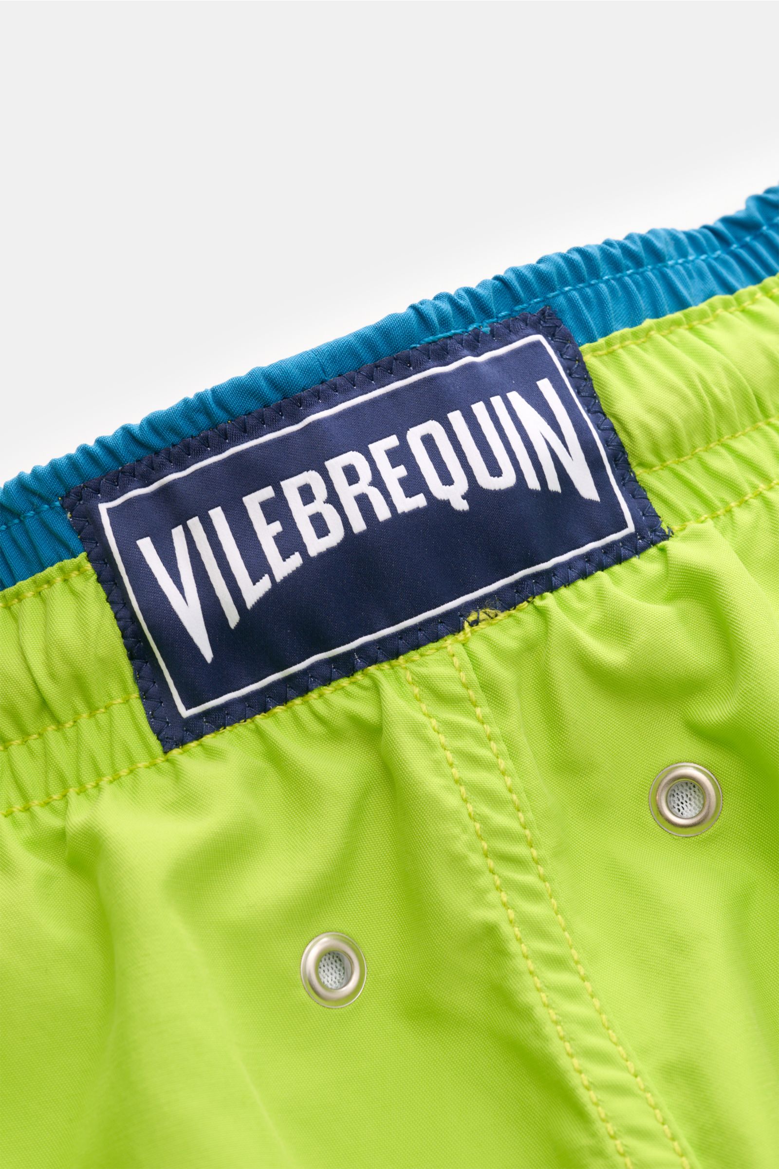 Nahaufnahme der Vilebrequin Badeshorts 'Moka' neongrün/petrol mit elastischem Bund, Tunnelzug und VILEBREQUIN-Logo.