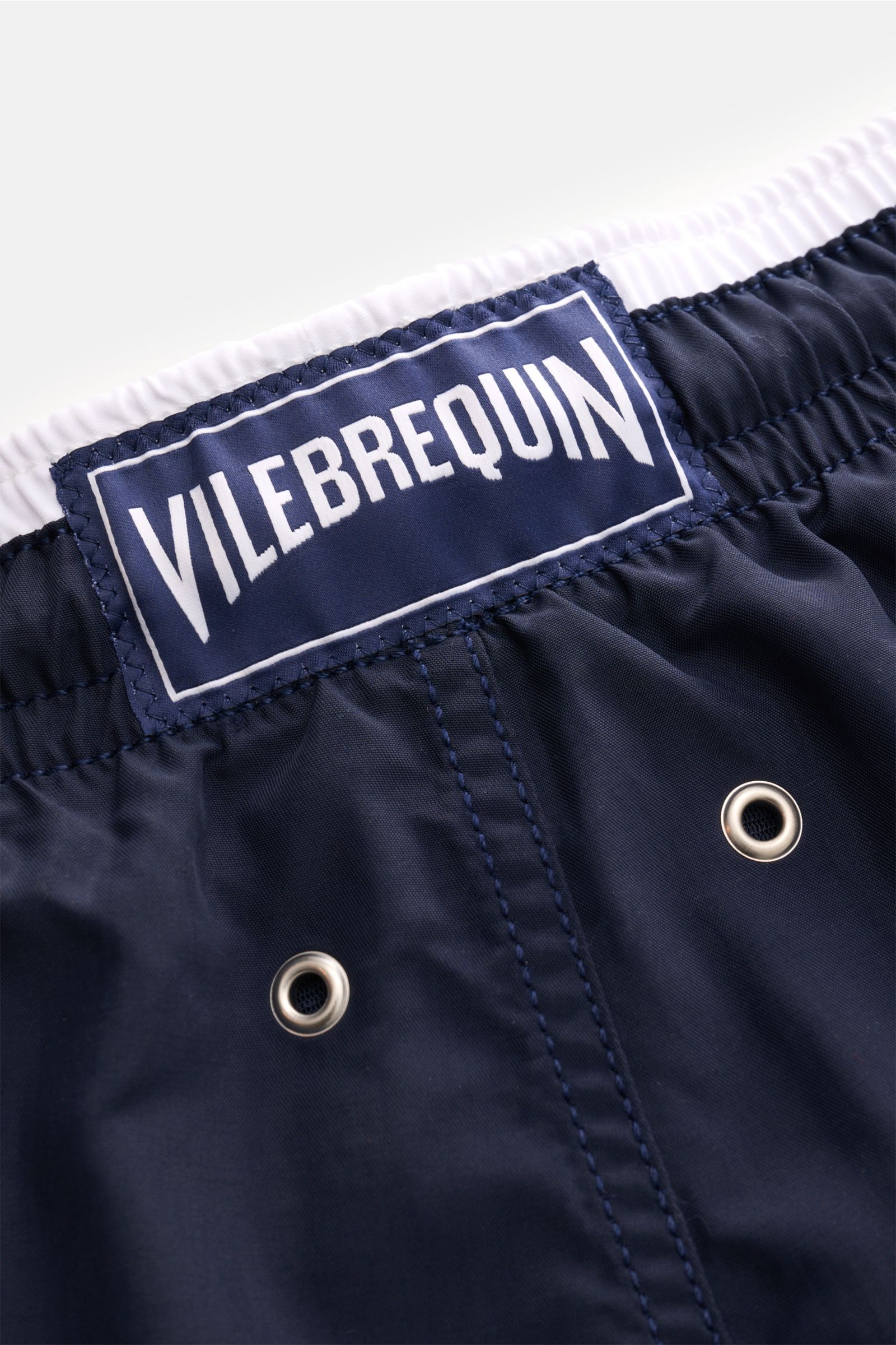 Nahaufnahme der Rückseite der Vilebrequin Badeshorts 'Moka' navy mit elastischem Bund, VILEBREQUIN-Label und Entwässerungsösen aus Microfaser.