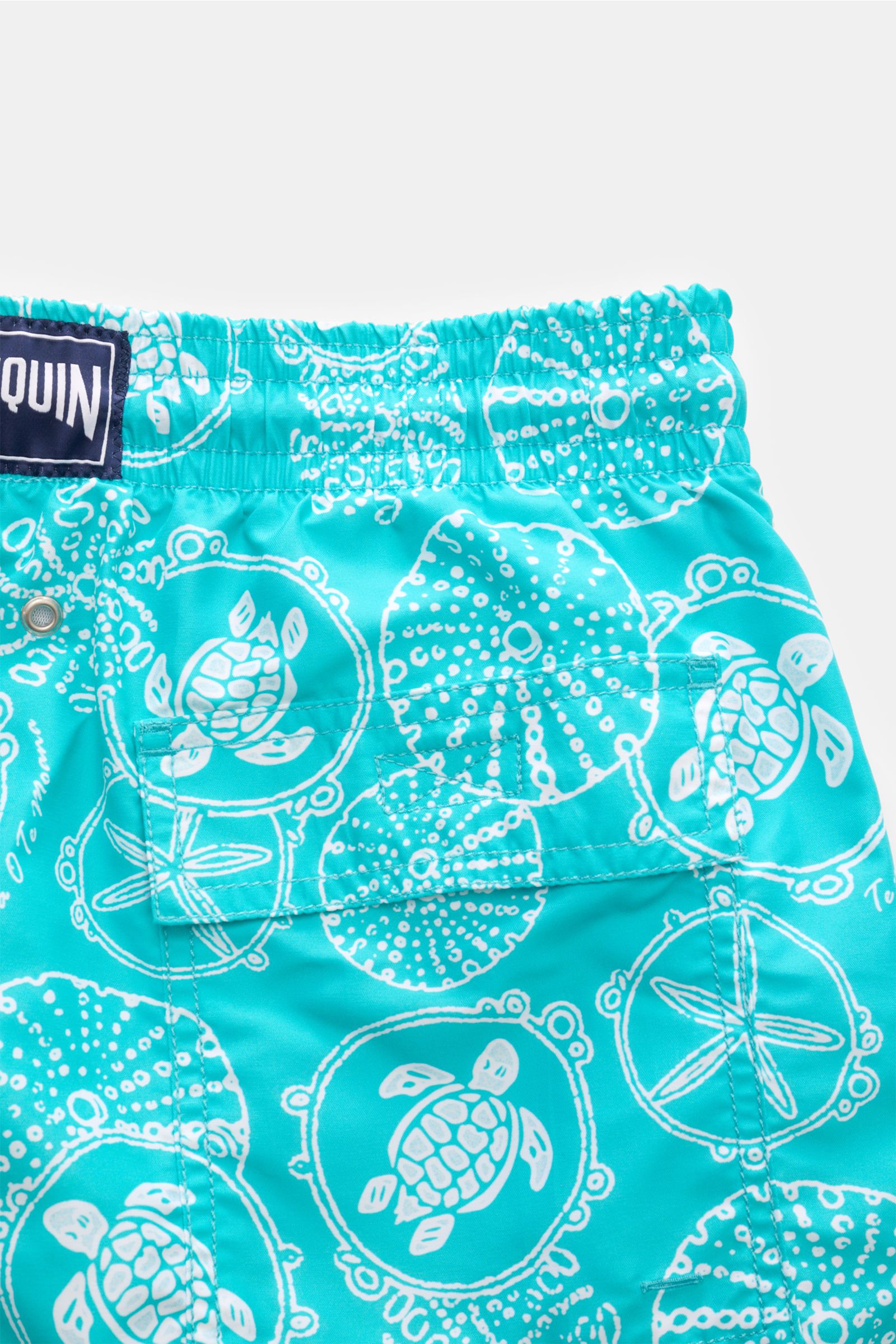 Close-up rear view of Vilebrequin Swim shorts 'Moorea' turquoise/white patterned, showing elasticated waistband, back pocket, and detailed sea turtle print.