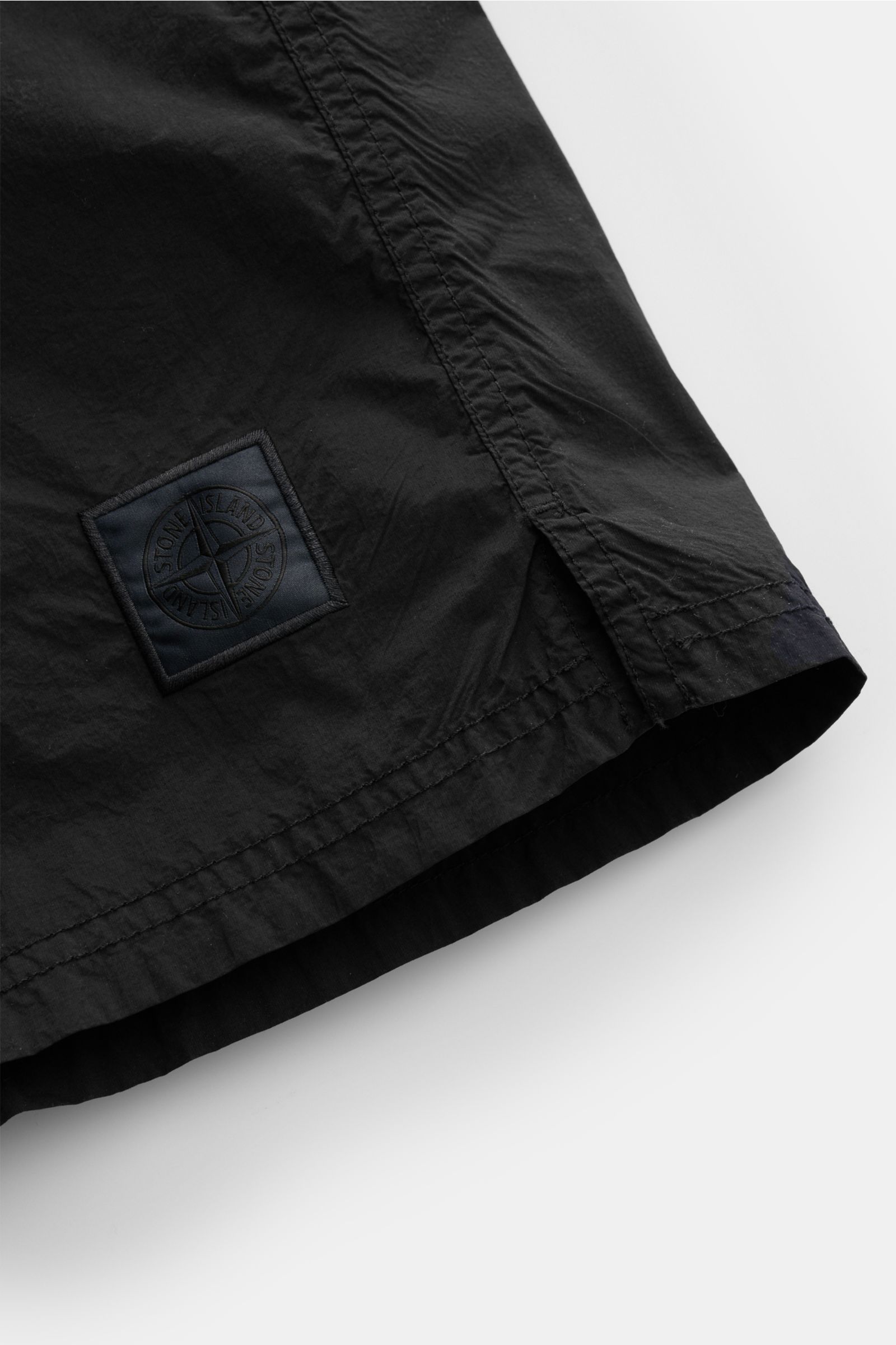 Stone Island Badeshorts 'Ghost Piece' dark navy, Detailansicht Saum mit monochromem Weblabel, hochwertige Microfaser, Regular Fit, elastischer Bund.