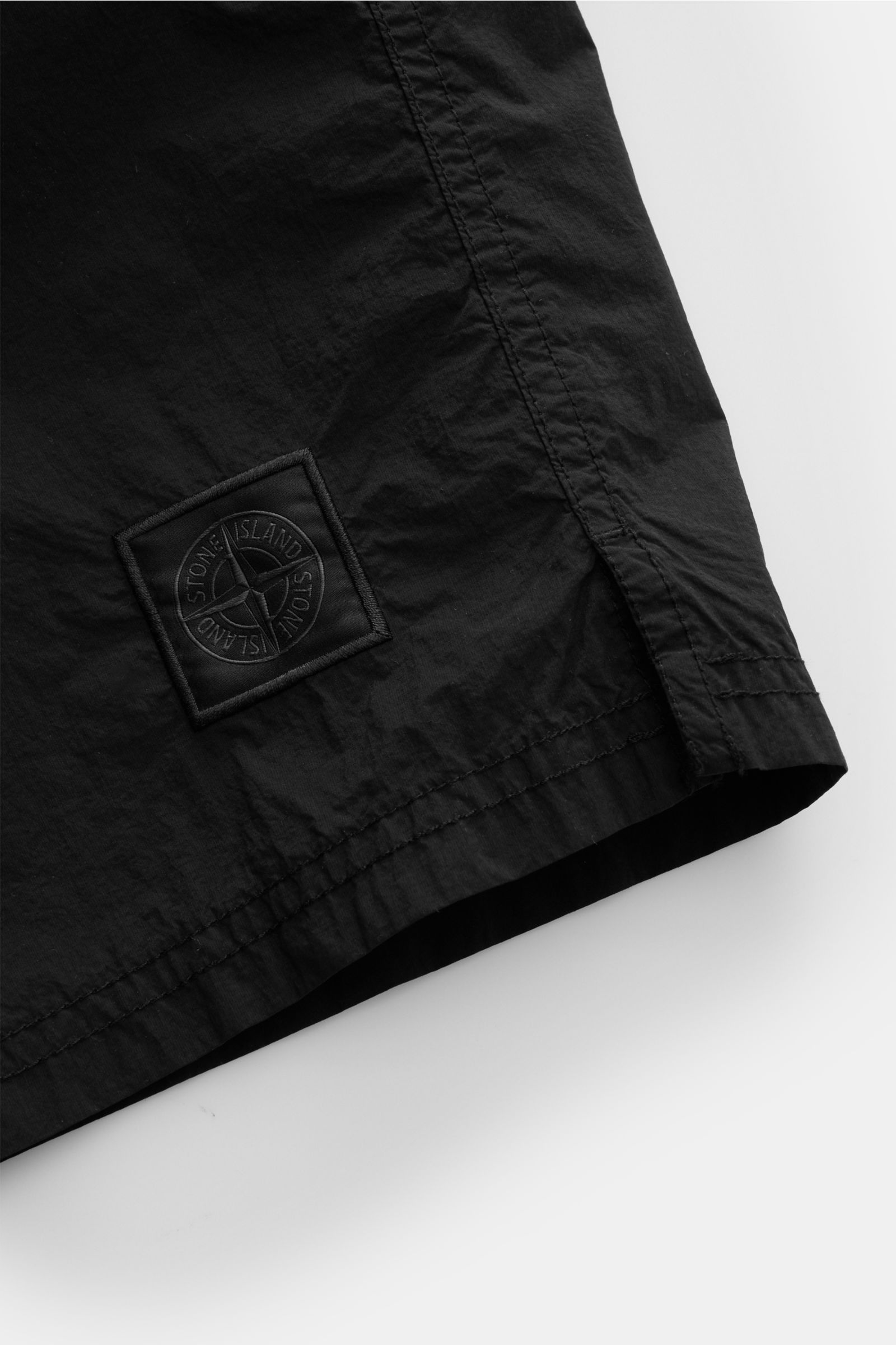 Stone Island Badeshorts 'Ghost Piece' schwarz, Detailaufnahme des Saums und monochromes Weblabel, Microfaser, Regular Fit, elastischer Bund, Mesh-Innenfutter.
