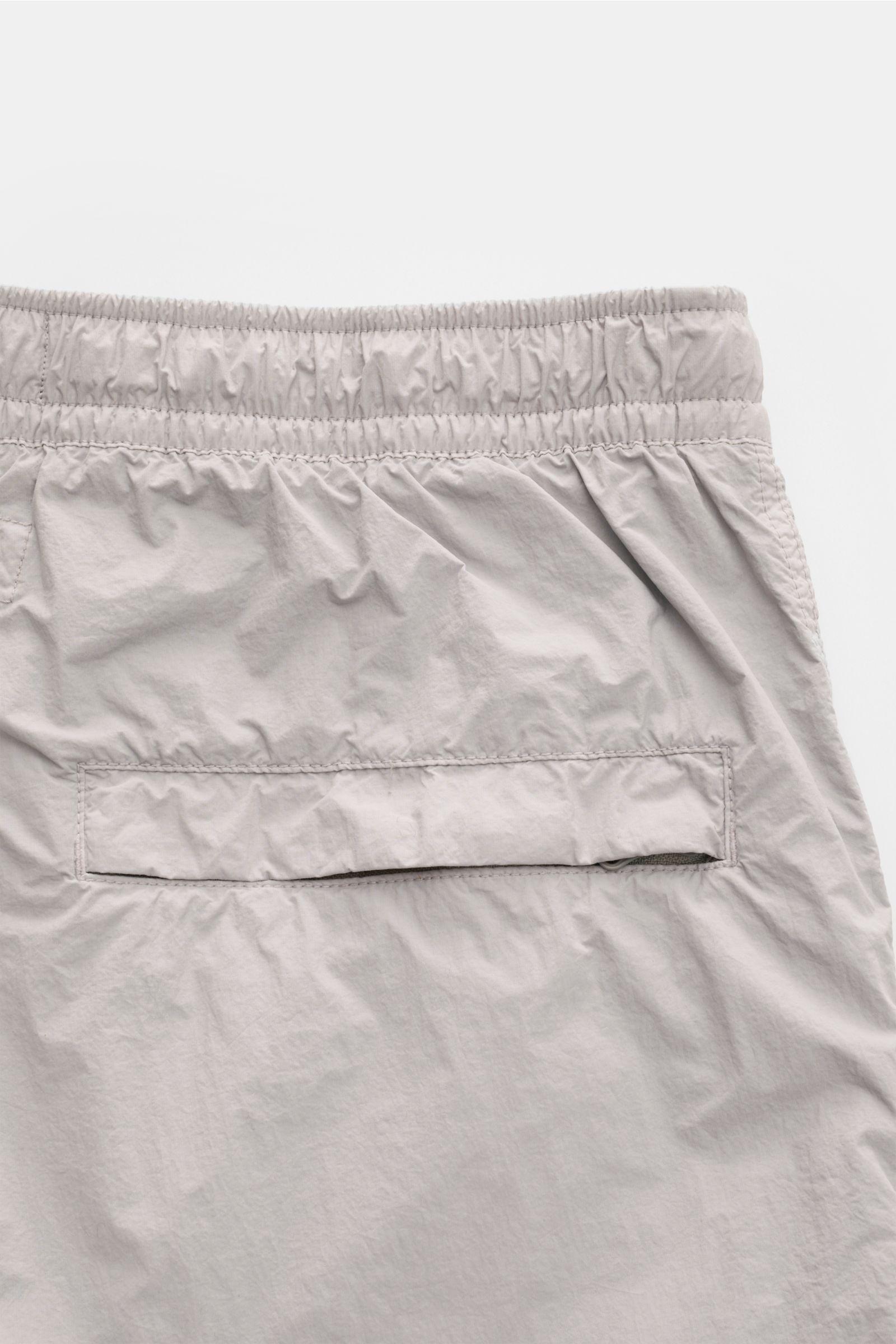 Close-up rear view of Stone Island Swim shorts 'Ghost Piece' grey showing elasticated waistband and back pocket with flap.

Description:  
A monochrome look in classic STONE ISLAND style: on the beach or at the pool, these swim shorts from the 'Ghost C