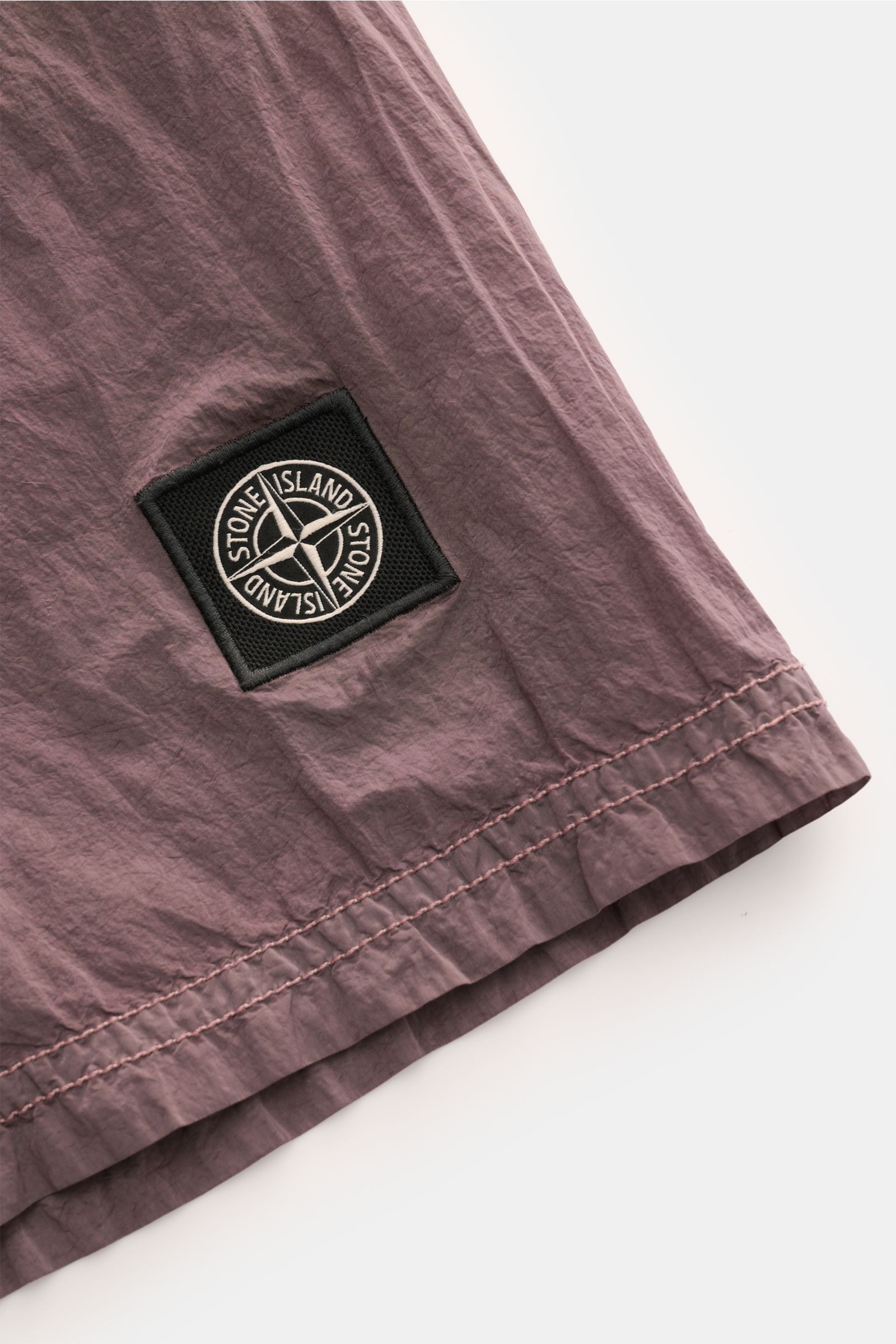 Stone Island Badeshorts altrosa aus recycelter Microfaser, Nahaufnahme Saum mit Weblabel, glatte Qualität, Regular Fit, elastischer Bund.