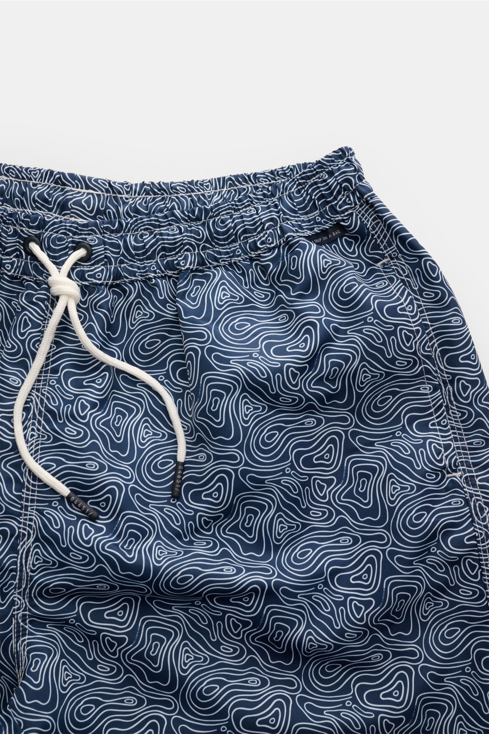 04651/ A trip in a bag Badeshorts 'Seamap' navy/weiß gemustert, Nahaufnahme von oben, elastischer Bund mit Tunnelzug, schnelltrocknende Microfaser, Seekarten-Muster.