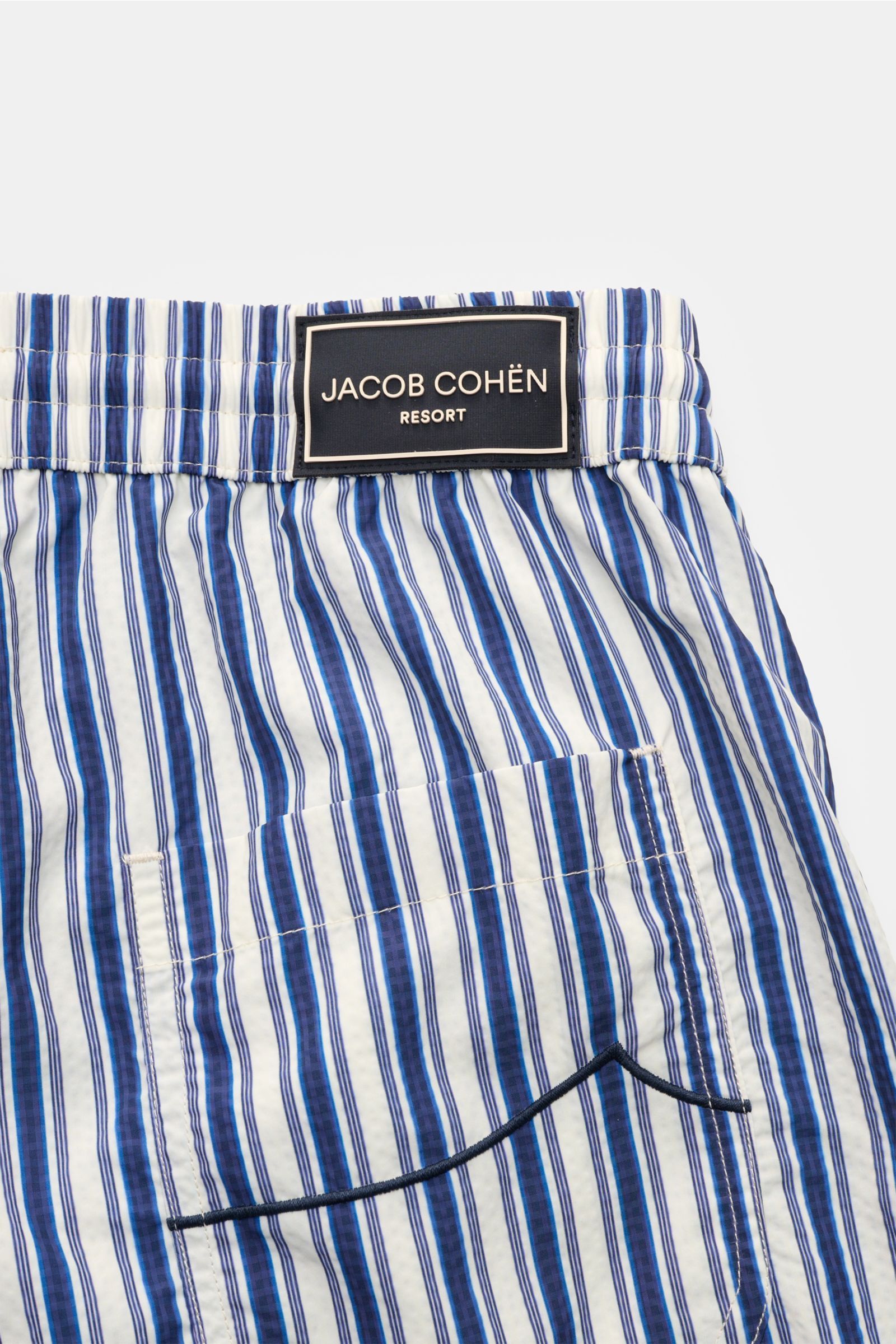 Close-up back view of Jacob Cohen Swim shorts navy/white striped featuring elastic waistband, patch pocket, and classic striped pattern.

Description:
Perfect for sunny days: These swim shorts by JACOB COHEN combine flowing material with a classic stri