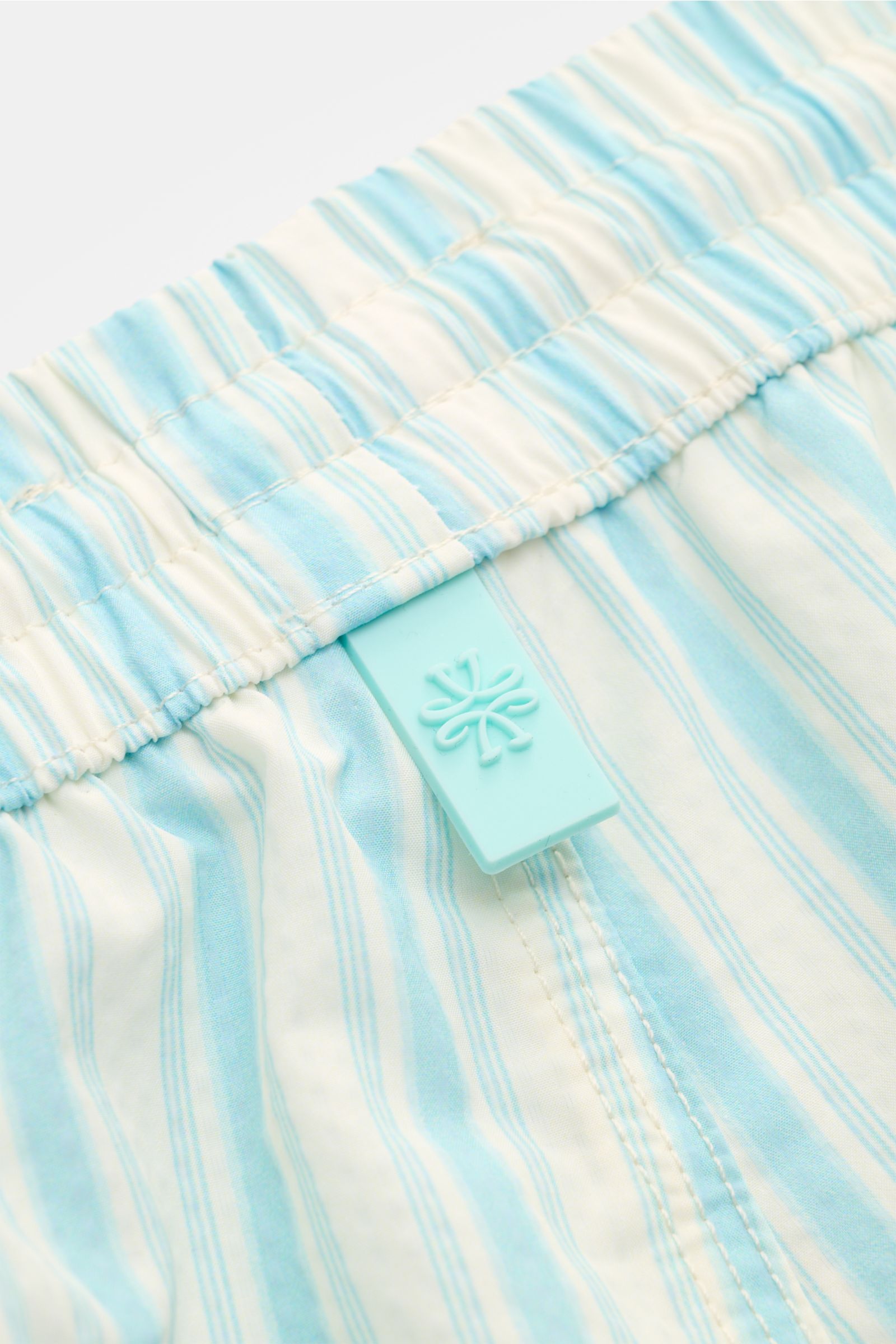 Close-up from above of Jacob Cohen Swim shorts light blue/white striped elasticated waistband with classic stripes and logo tag.

Description: Perfect for sunny days: These swim shorts by JACOB COHEN combine flowing material with a classic striped desi