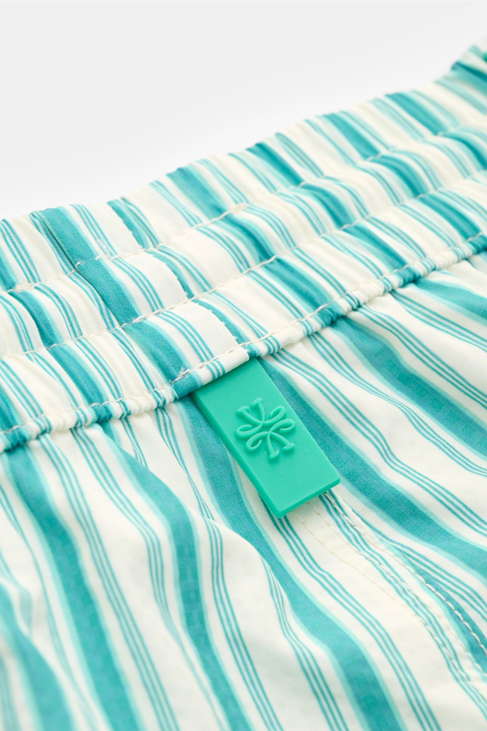 Nahaufnahme der Jacob Cohen Badeshorts türkis/weiß gestreift von oben, elastischer Bund mit Tunnelzug, weiche Microfaser, Regular Fit, Mesh-Innenfutter.
