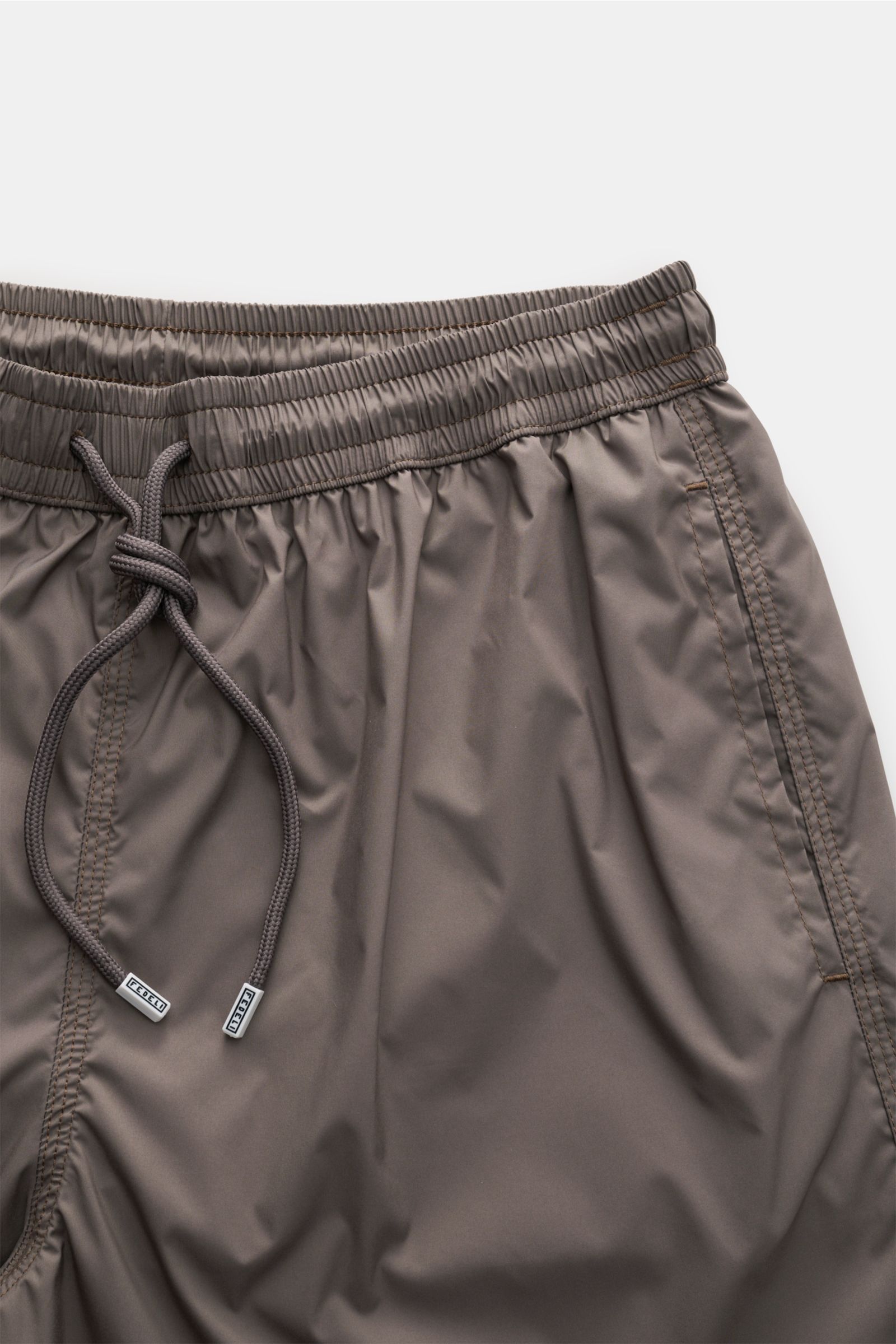 Fedeli Swim shorts 'Madeira Airstop' brown shown from a top-front view with elastic waistband and drawstring. The swim shorts 'Madeira Airstop' by FEDELI are a timeless model for your suitcase. With their comfortable elasticated waistband and monochrom