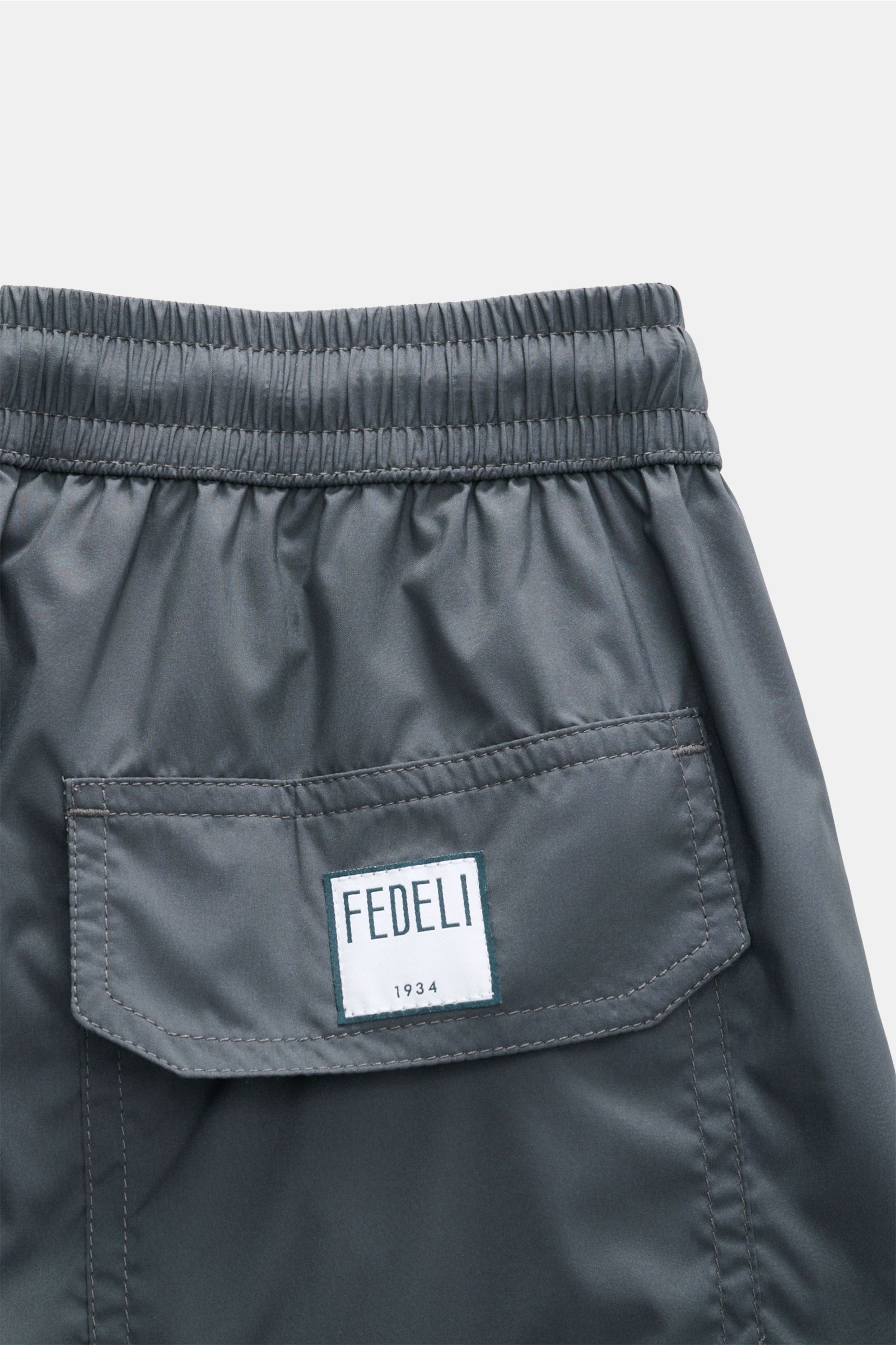 Close-up rear view of Fedeli Swim shorts 'Madeira Airstop' dark grey showing elasticated waistband and back pocket with FEDELI label.

The swim shorts 'Madeira Airstop' by FEDELI are a timeless model for your suitcase. With their comfortable elasticate