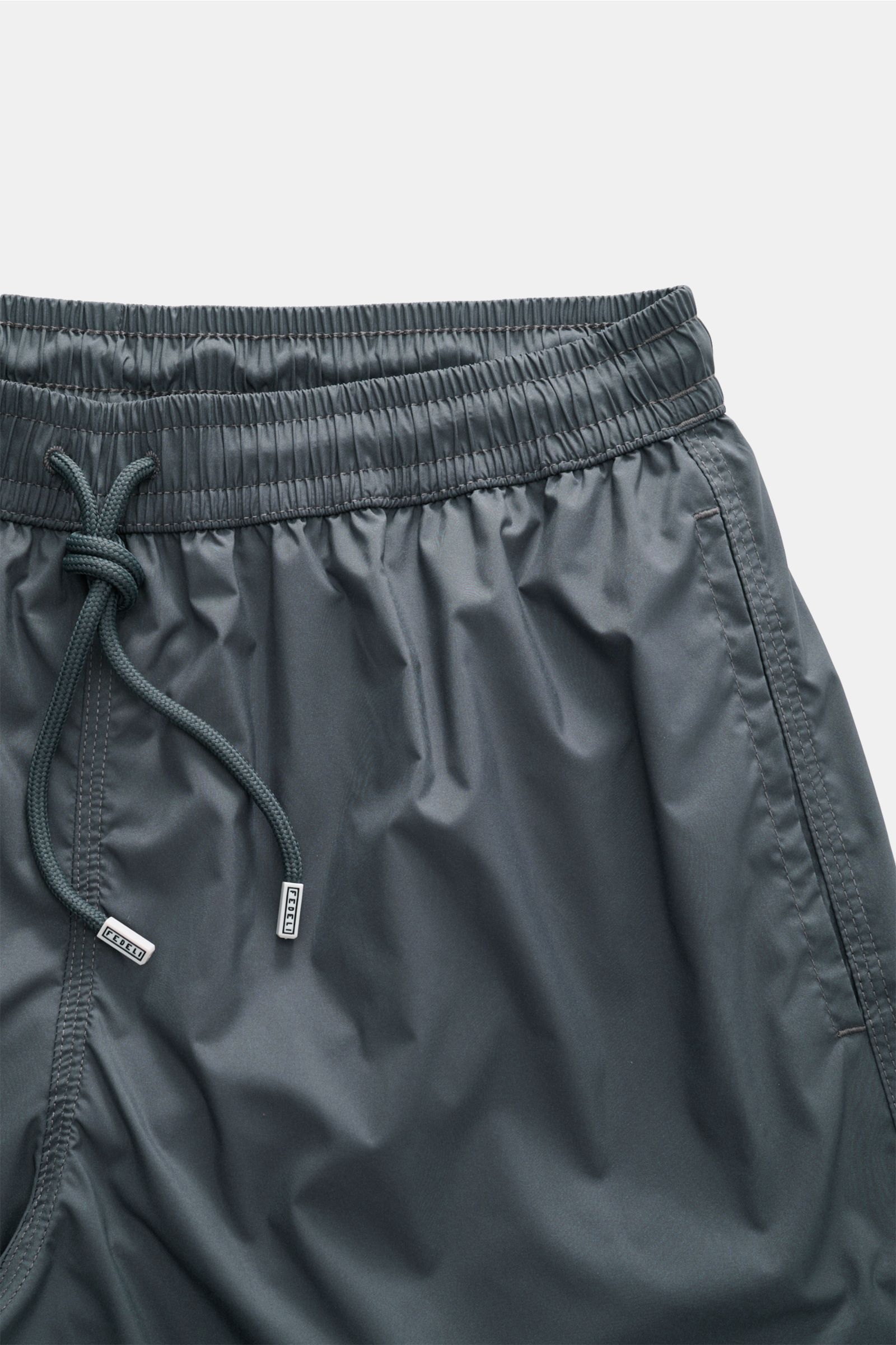 Fedeli Swim shorts 'Madeira Airstop' dark grey shown from front close-up, elasticated waistband with drawstring and side seam pocket.

The swim shorts 'Madeira Airstop' by FEDELI are a timeless model for your suitcase. With their comfortable elasticate