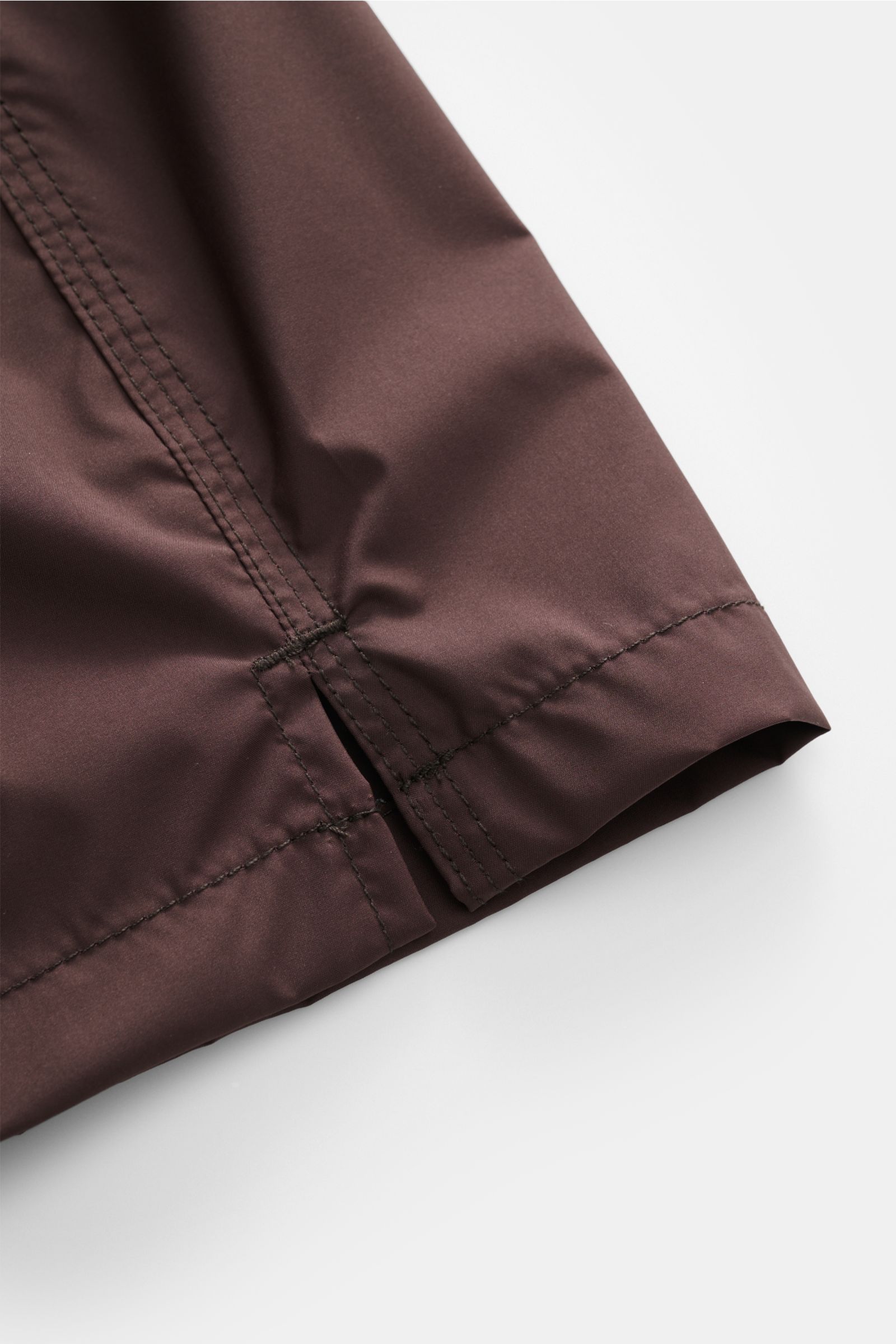 Nahaufnahme der Fedeli Badeshorts 'Madeira Airstop' dunkelbraun, seitliche Perspektive zeigt Saum mit kurzen Schlitzen aus schnelltrocknender Microfaser.