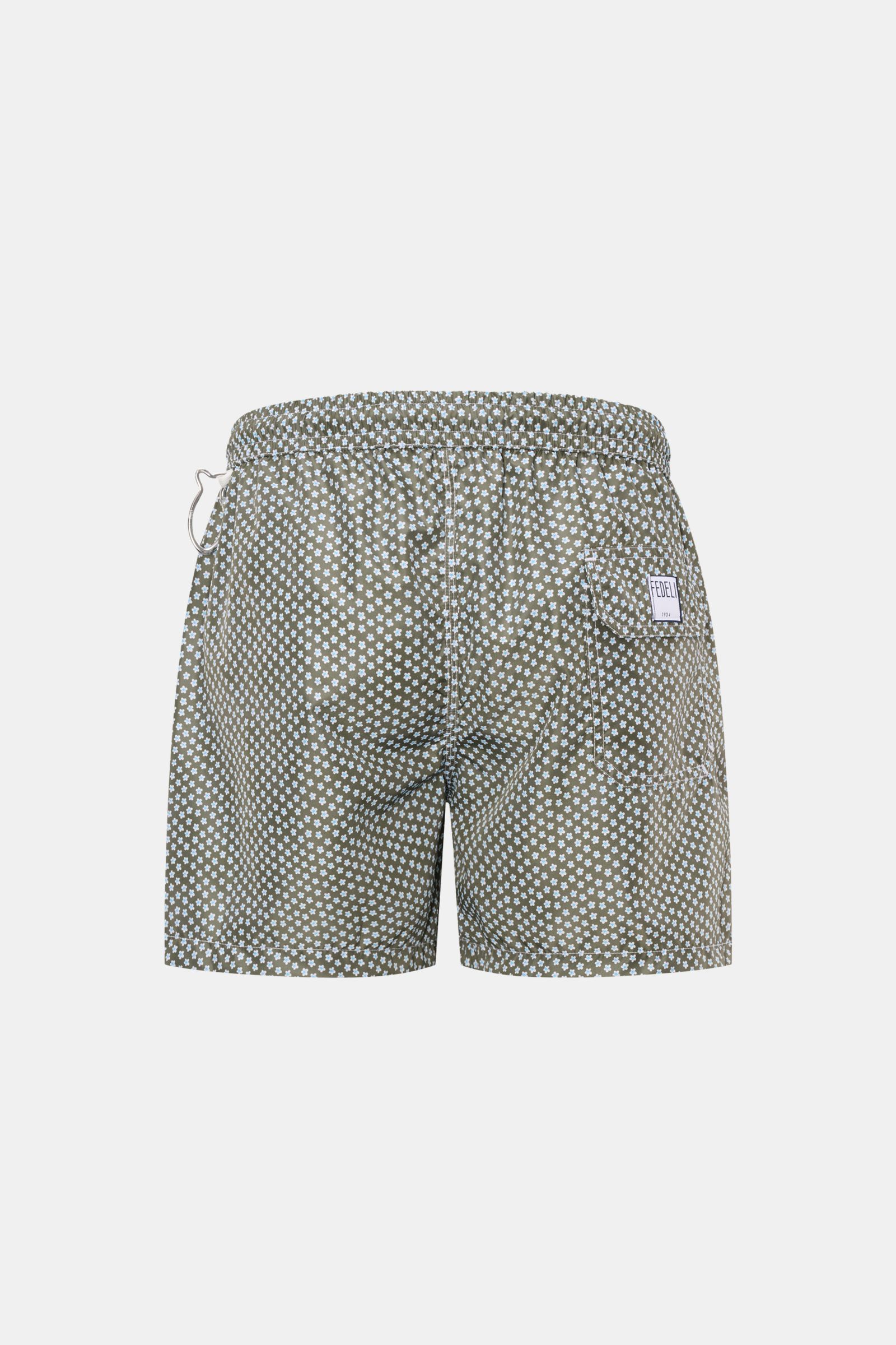 Rear view of Fedeli Swim shorts 'Madeira Airstop' green/white/light blue patterned with elasticated waistband, back pocket, and whale-shaped carabiner.

Description: An essential for your summer vacation: These FEDELI swim shorts have an expressive pat