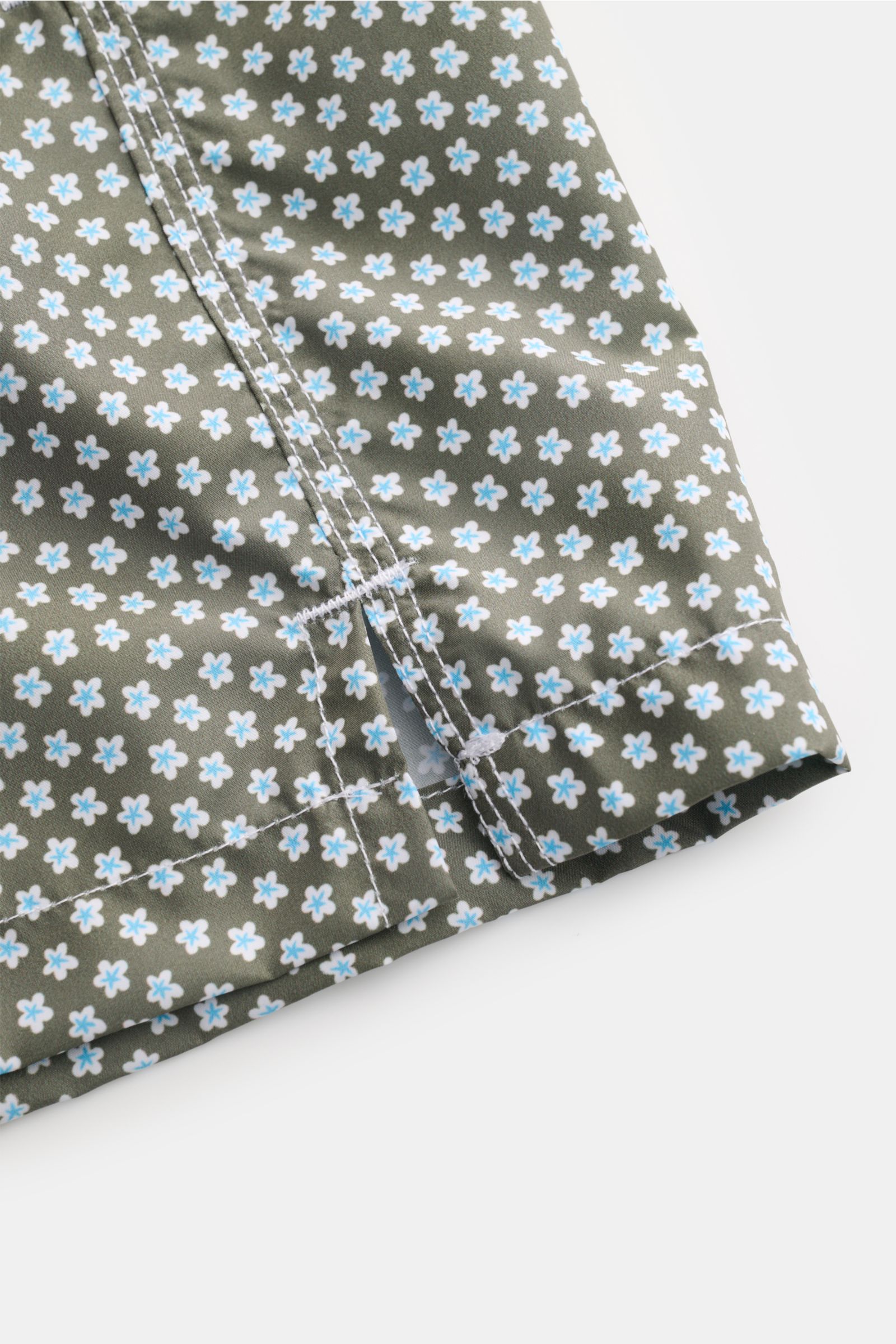 Close-up side view of Fedeli Swim shorts 'Madeira Airstop' green/white/light blue patterned hem with side vents and detailed stitching.

An essential for your summer vacation: These FEDELI swim shorts have an expressive pattern that adds stylish accent