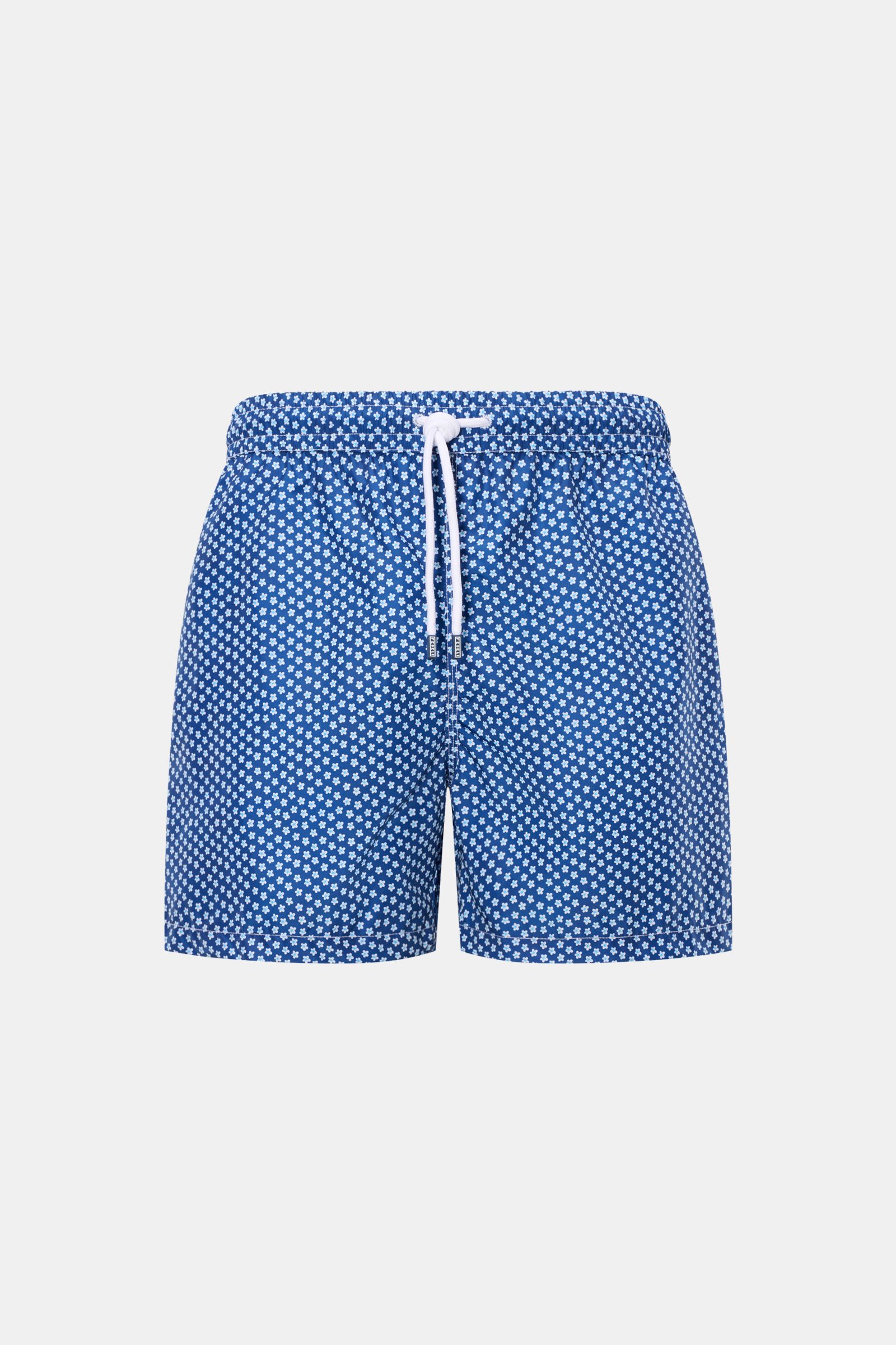 Front view of Fedeli Swim shorts 'Madeira Airstop' blue/white/light blue patterned with elasticated waistband, white drawstring, and floral design.

Description: An essential for your summer vacation: These FEDELI swim shorts have an expressive pattern th