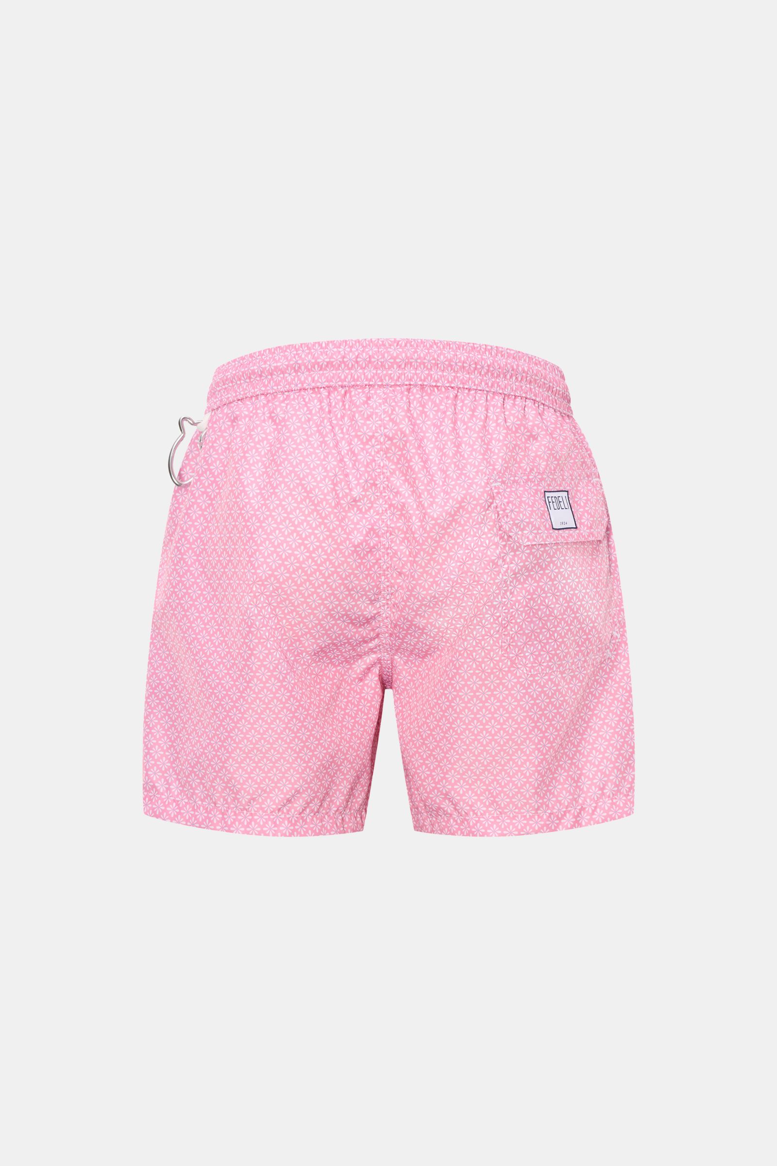 Back view of Fedeli Swim shorts 'Madeira Airstop' rose/white patterned with elasticated waistband, whale-shaped carabiner, and floral pattern.

An essential for your summer vacation: These FEDELI swim shorts have an expressive pattern that adds stylish