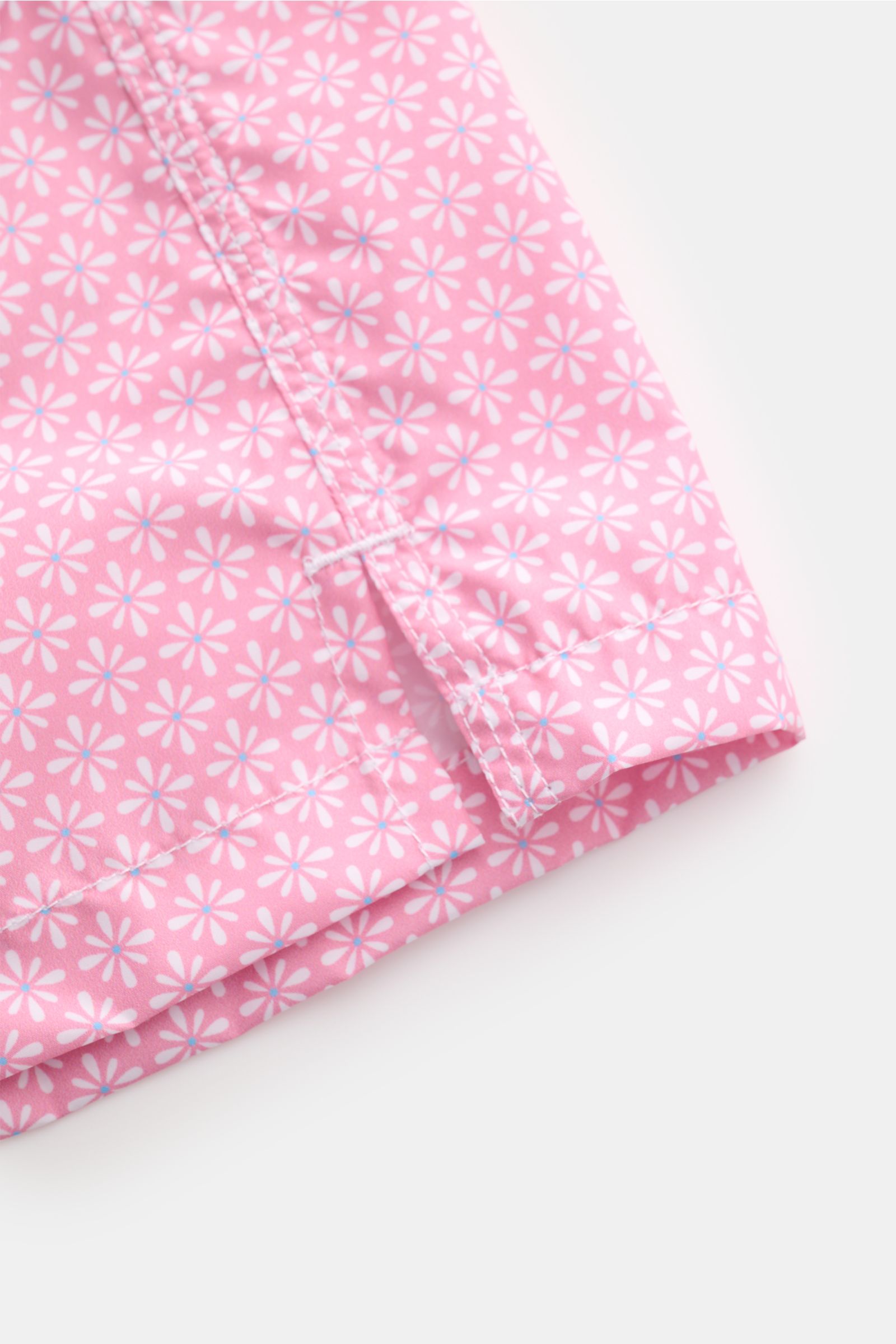 Close-up view of Fedeli Swim shorts 'Madeira Airstop' rose/white patterned hem with side vents, showing floral pattern and stitching detail.

Description: An essential for your summer vacation: These FEDELI swim shorts have an expressive pattern that a