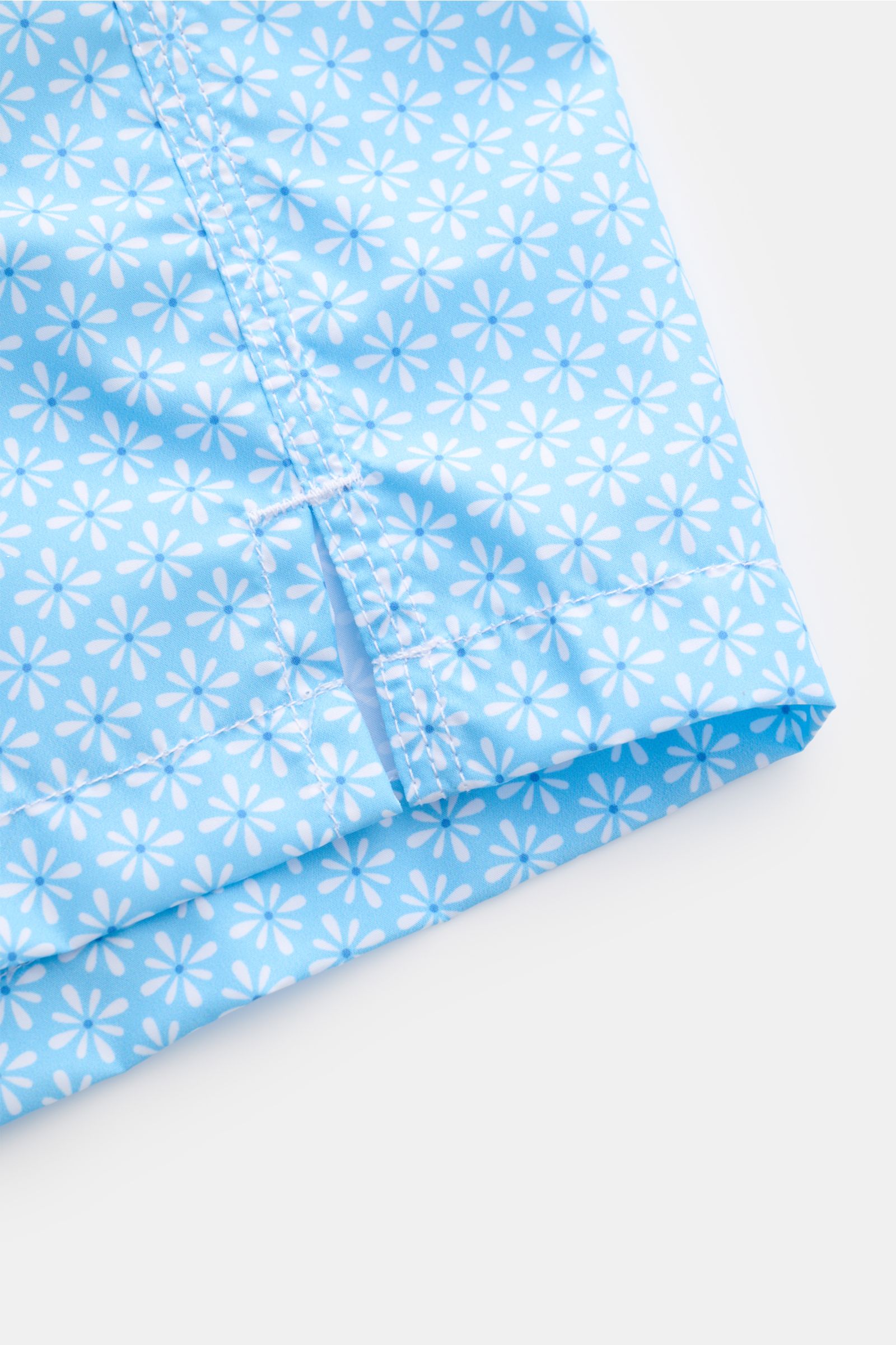 Close-up front-side view of Fedeli Swim shorts 'Madeira Airstop' light blue/white patterned with floral design and side vents.

An essential for your summer vacation: These FEDELI swim shorts have an expressive pattern that adds stylish accents and mak