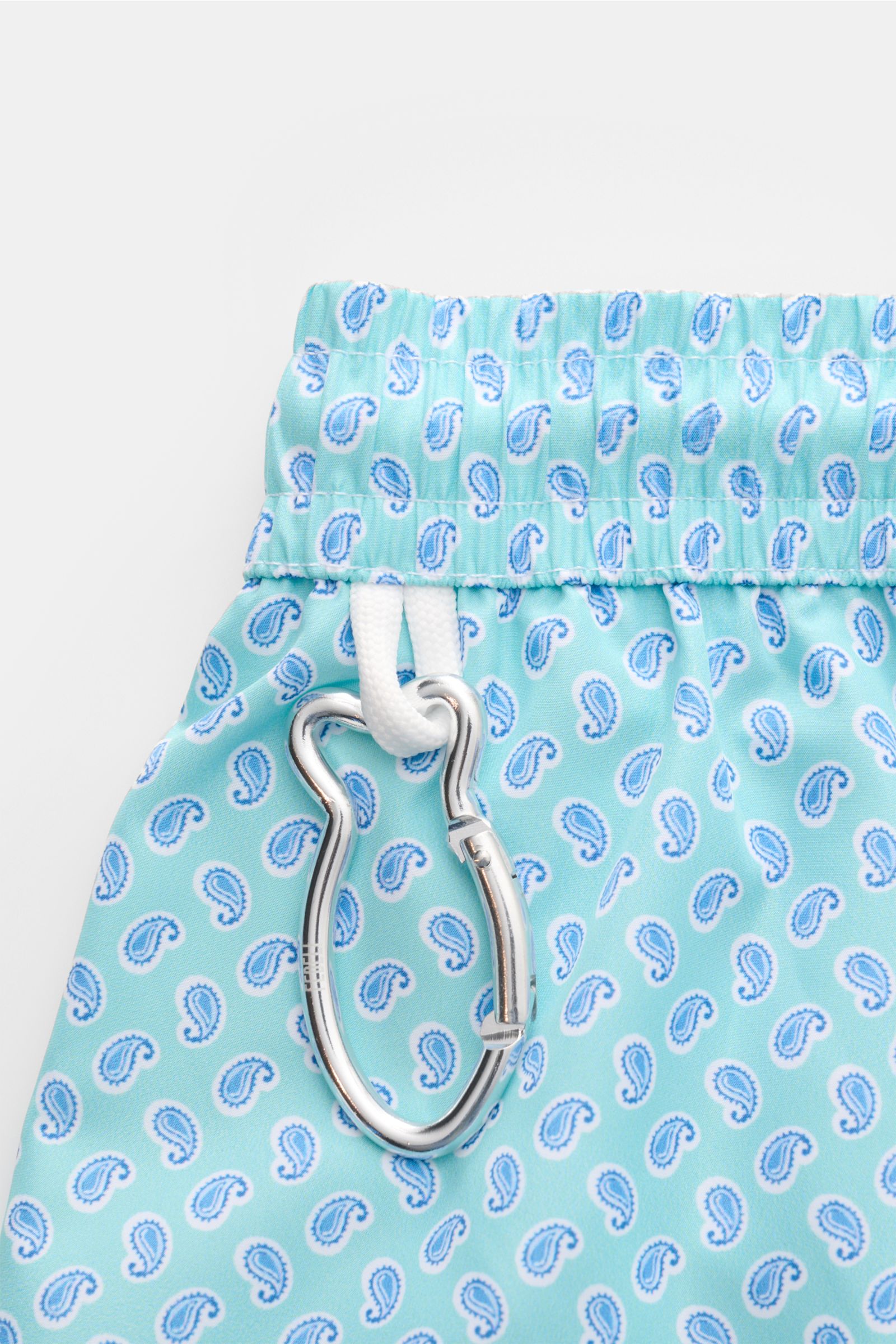 Fedeli Badeshorts 'Madeira Airstop' türkis/weiß/blau gemustert mit Paisley, elastischem Bund, Karabinerhaken in Walform, Detailaufnahme von oben.