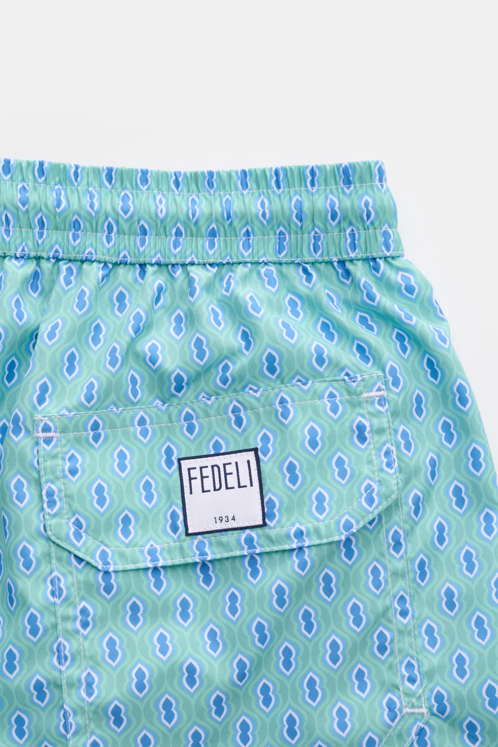 Fedeli Swim shorts 'Madeira Airstop' turquoise/blue/white patterned, rear view with elastic waistband, side vents, and FEDELI label on back pocket. An essential for your summer vacation: These FEDELI swim shorts have an expressive pattern that adds stylis