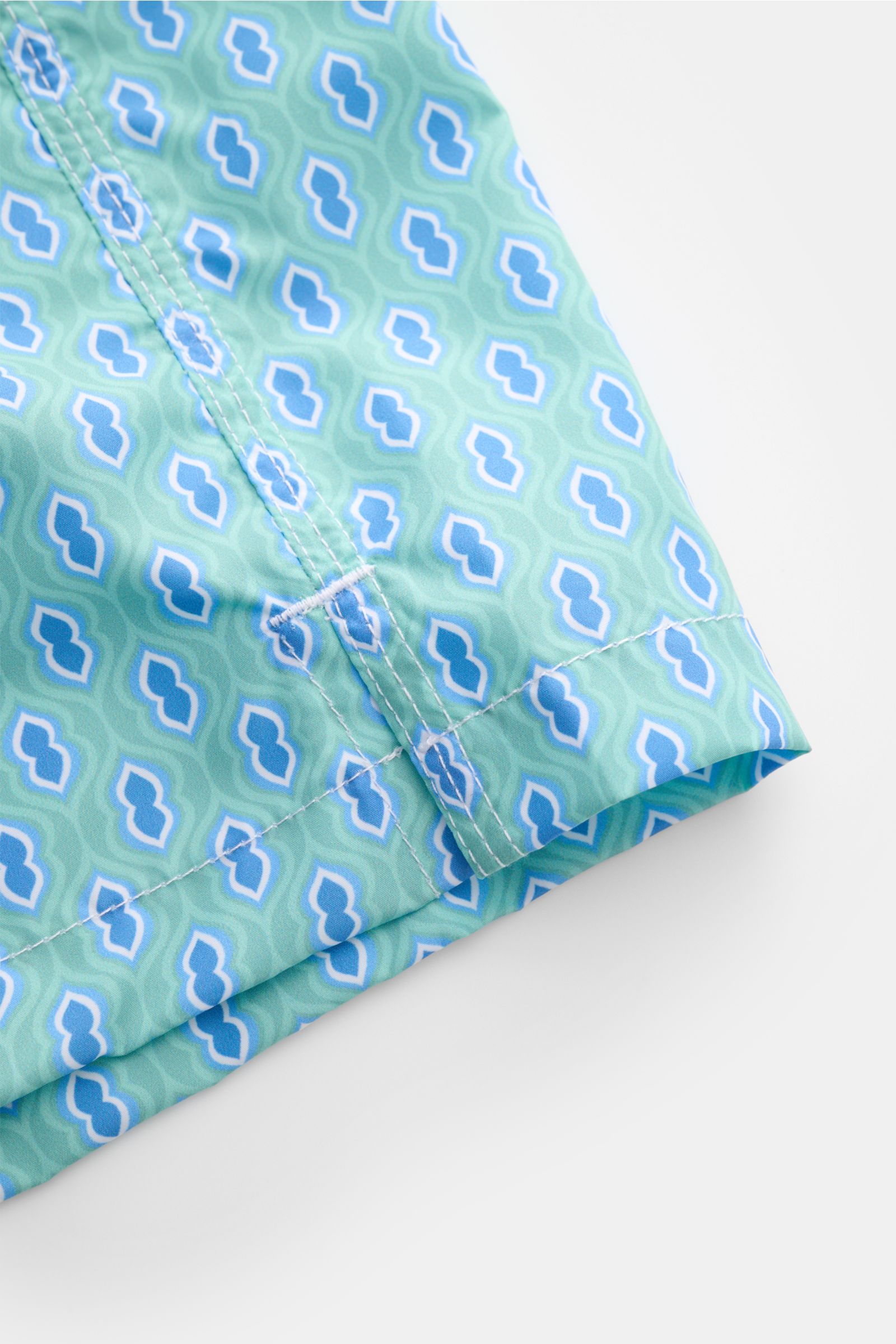 Close-up front-angle view of Fedeli Swim shorts 'Madeira Airstop' turquoise/blue/white patterned with graphic design and stitched hem.

An essential for your summer vacation: These FEDELI swim shorts have an expressive pattern that adds stylish accents