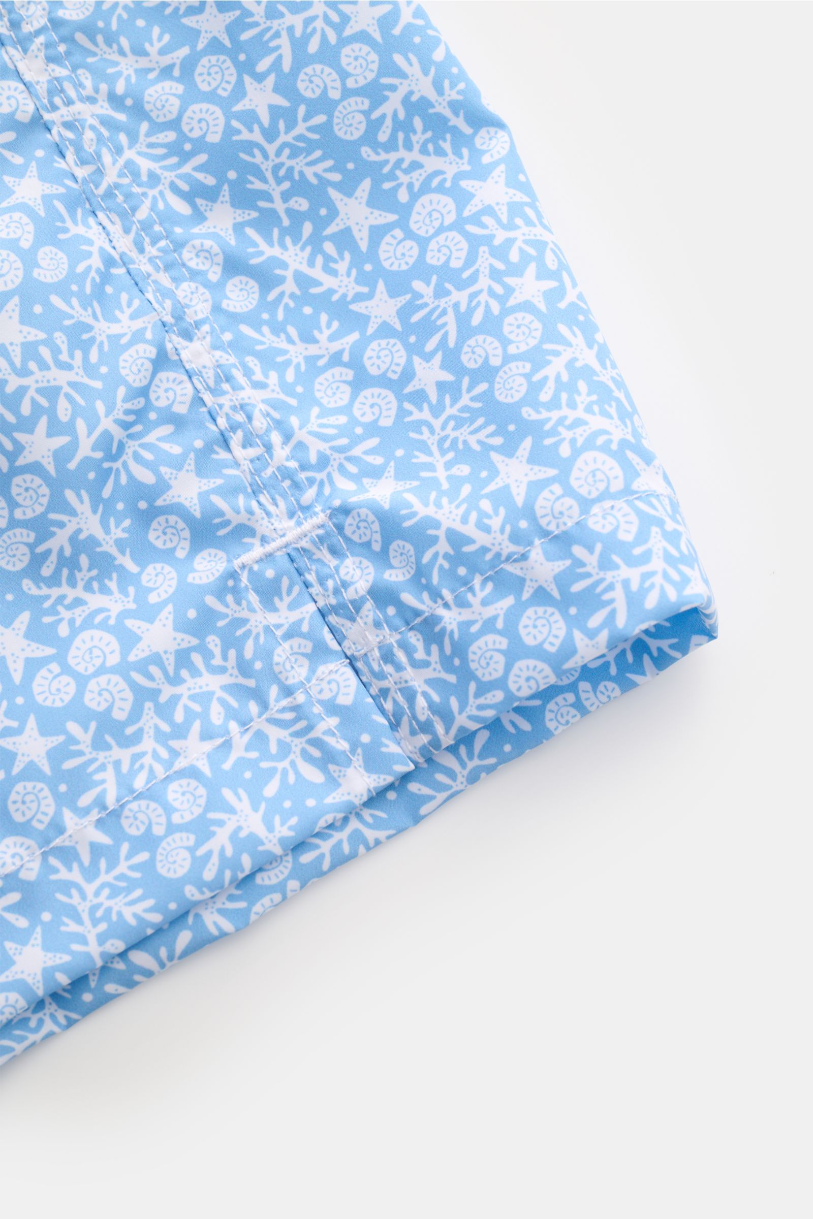 Close-up front view of Fedeli Swim shorts 'Madeira Airstop' light blue/white patterned with nautical design and hem side vents.

An essential for your summer vacation: These FEDELI swim shorts have an expressive pattern that adds stylish accents and ma