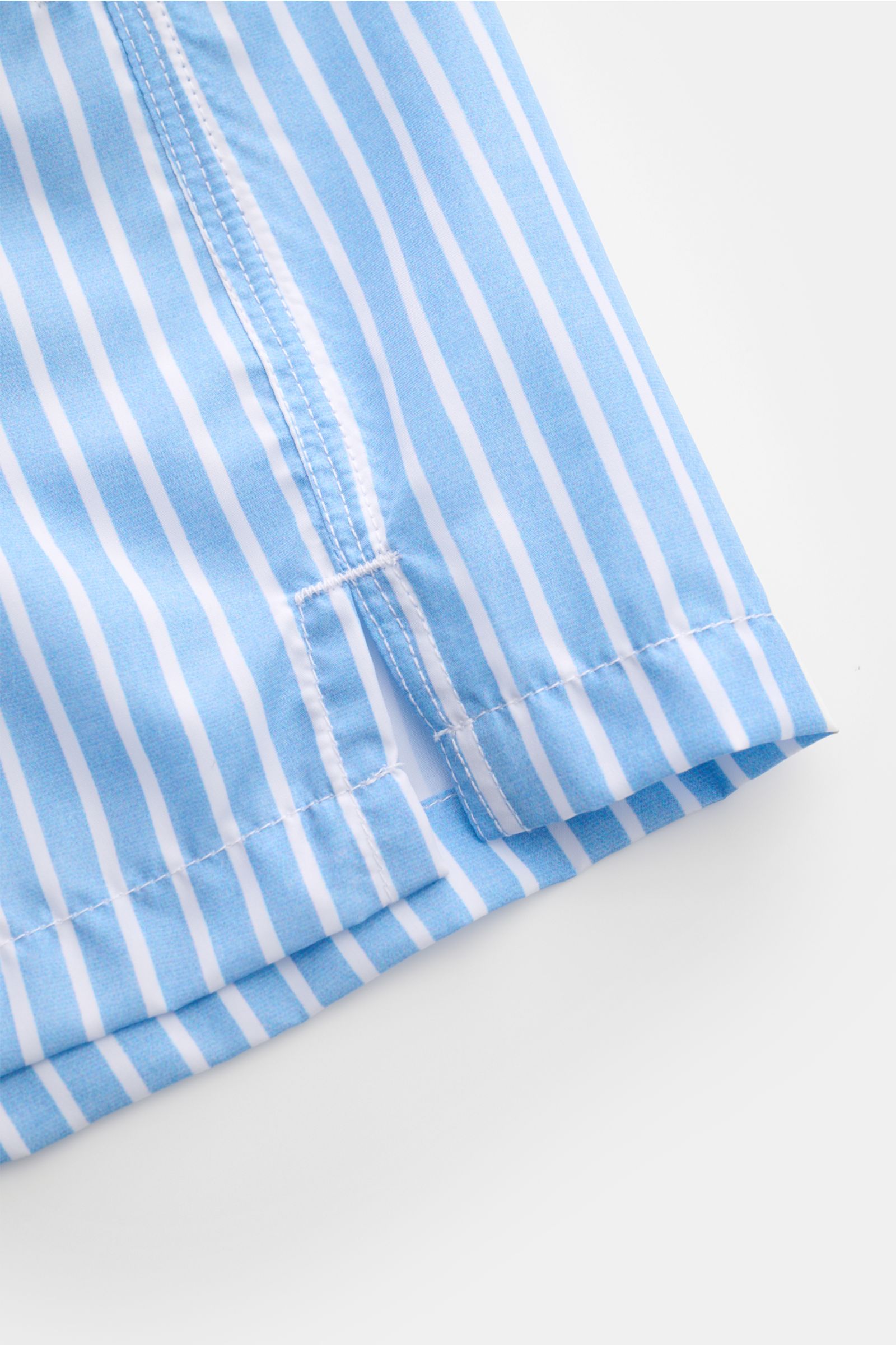 Alt-Tag (124 Zeichen):
Nahaufnahme der Fedeli Badeshorts 'Madeira Airstop' hellblau/weiß gestreift mit Saumschlitzen und feiner Microfaserstruktur.