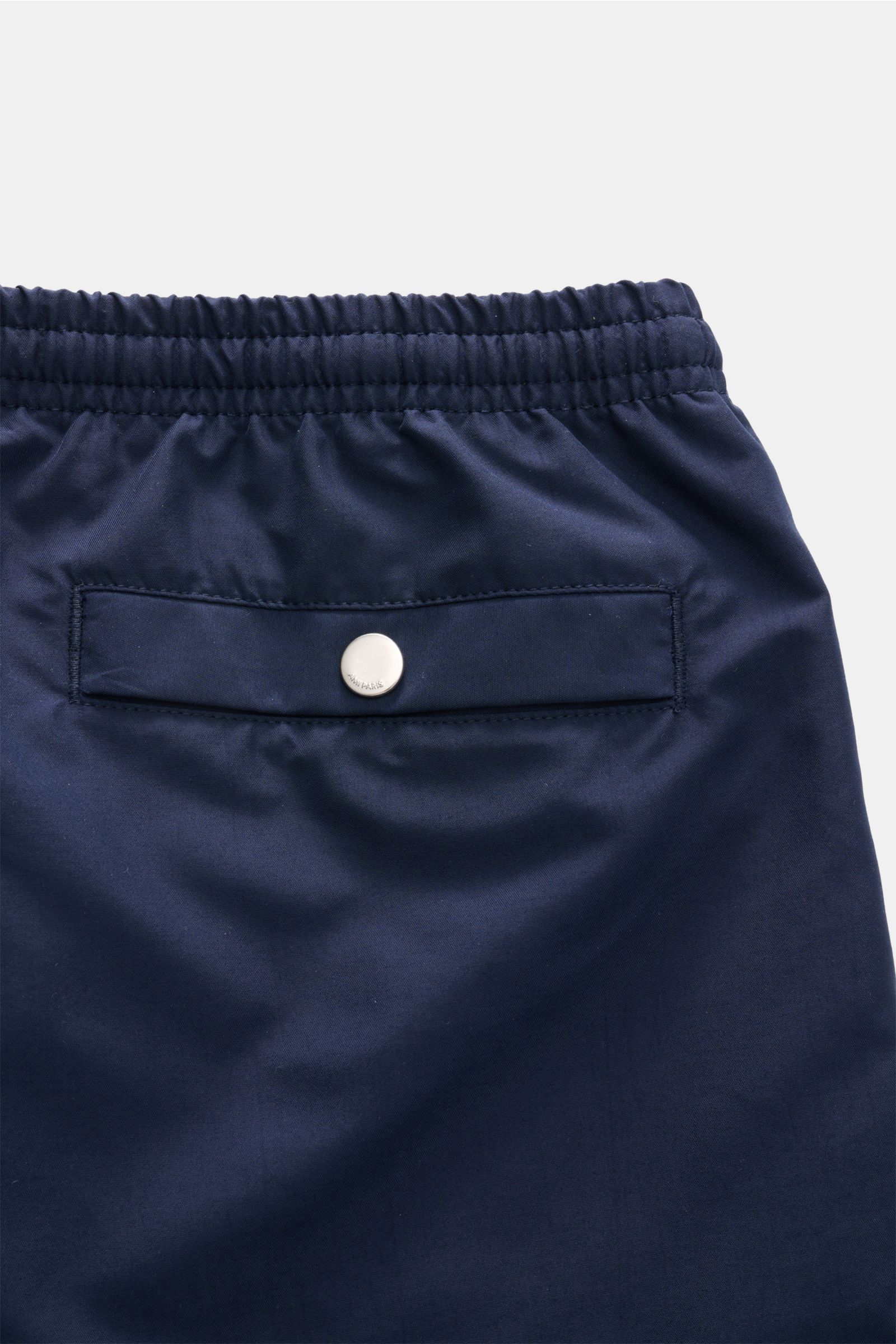Close-up rear view of Ami Paris Swim shorts navy showing elasticated waistband and back pocket with snap button.

Description: 
Perfect for beach and pool: These swim shorts by AMI PARIS combine sporty style with fine microfibre fabric.

Hi