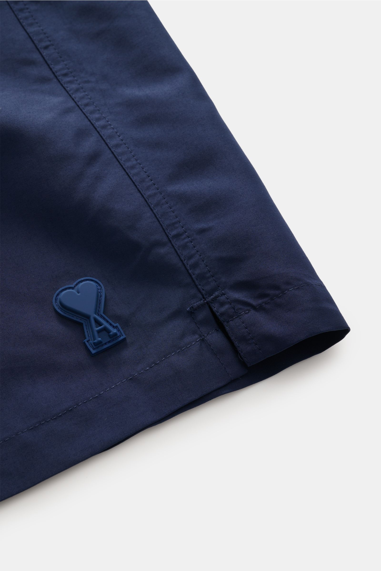Close-up side view of Ami Paris Swim shorts navy showing fine navy microfibre fabric with rubberised heart and A logo patch on hem.

Description: Perfect for beach and pool: These swim shorts by AMI PARIS combine sporty style with fine microfibre fabri