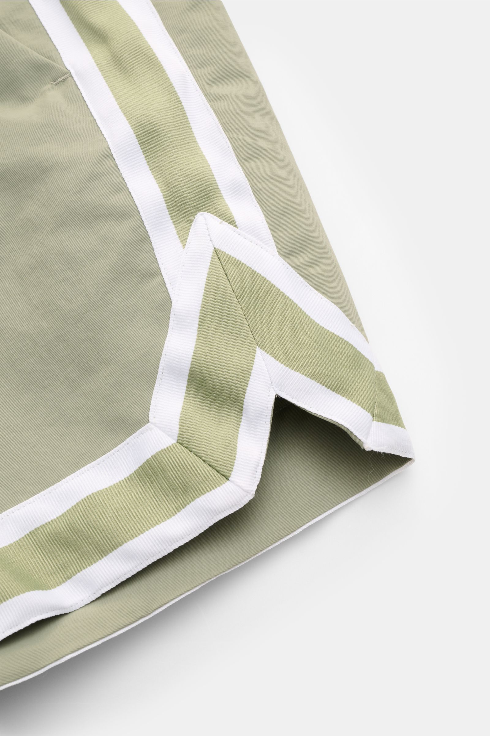 Nahaufnahme der Ché Badeshorts 'Baller' salbei in Retro-Optik, Detailansicht des glatten Microfaserstoffs mit weißem Grosgrain-Besatz.