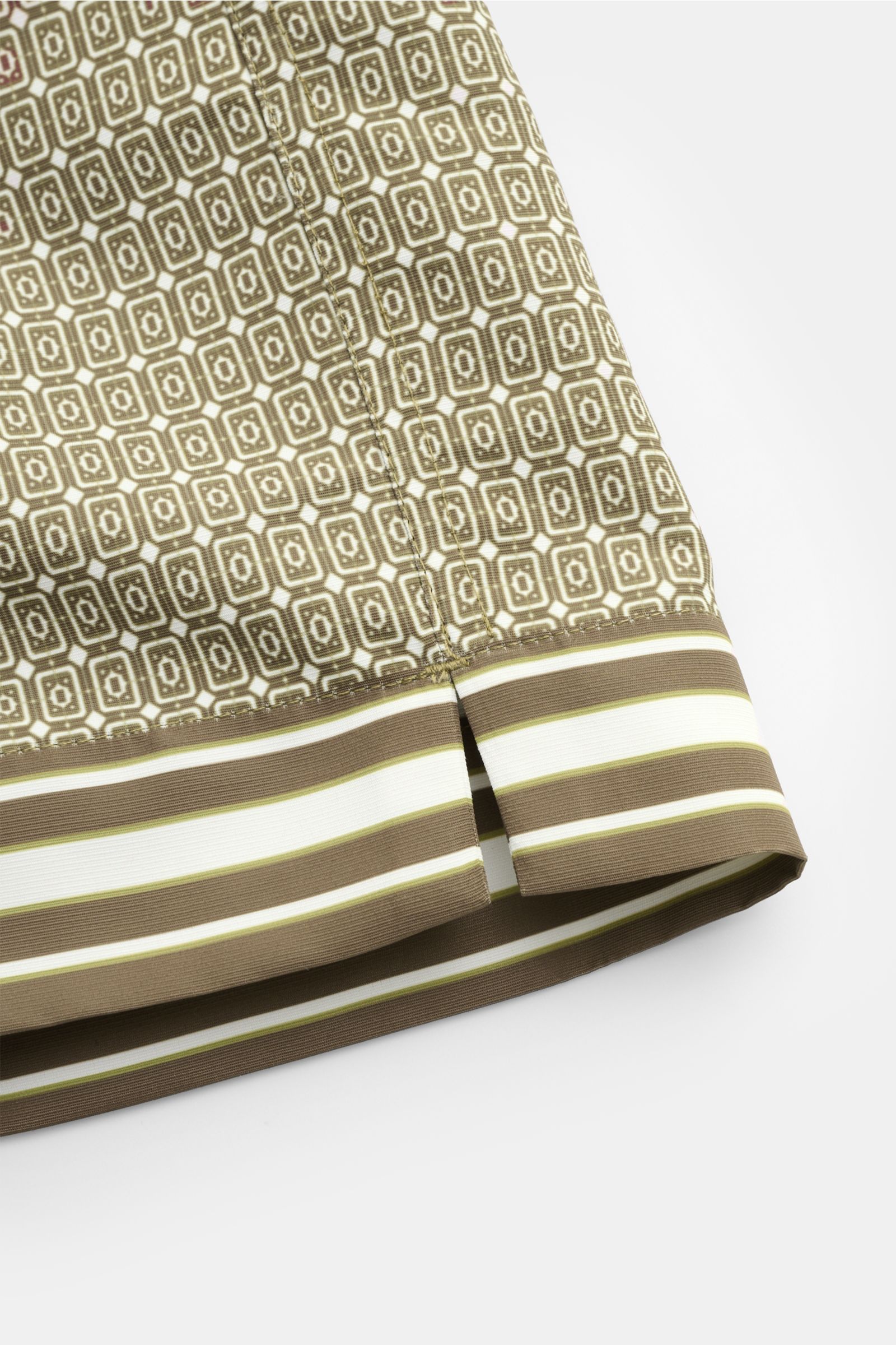 Nahaufnahme von Ché Badeshorts 'Lucena' grün/braun gemustert mit ornamentalem Print und gestreiftem Saum, glatter Microfaser, Regular Fit.