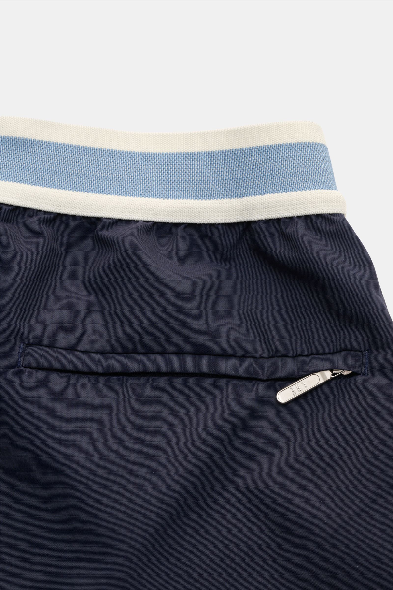 Alt tag (125 characters): Close-up rear view of Ché Swim shorts 'Baller' navy, showing waistband, back pocket with zipper, and fabric texture.

Description: The swim shorts 'Baller' by CHÉ give summery vibes and have a short cut in a retro design that 