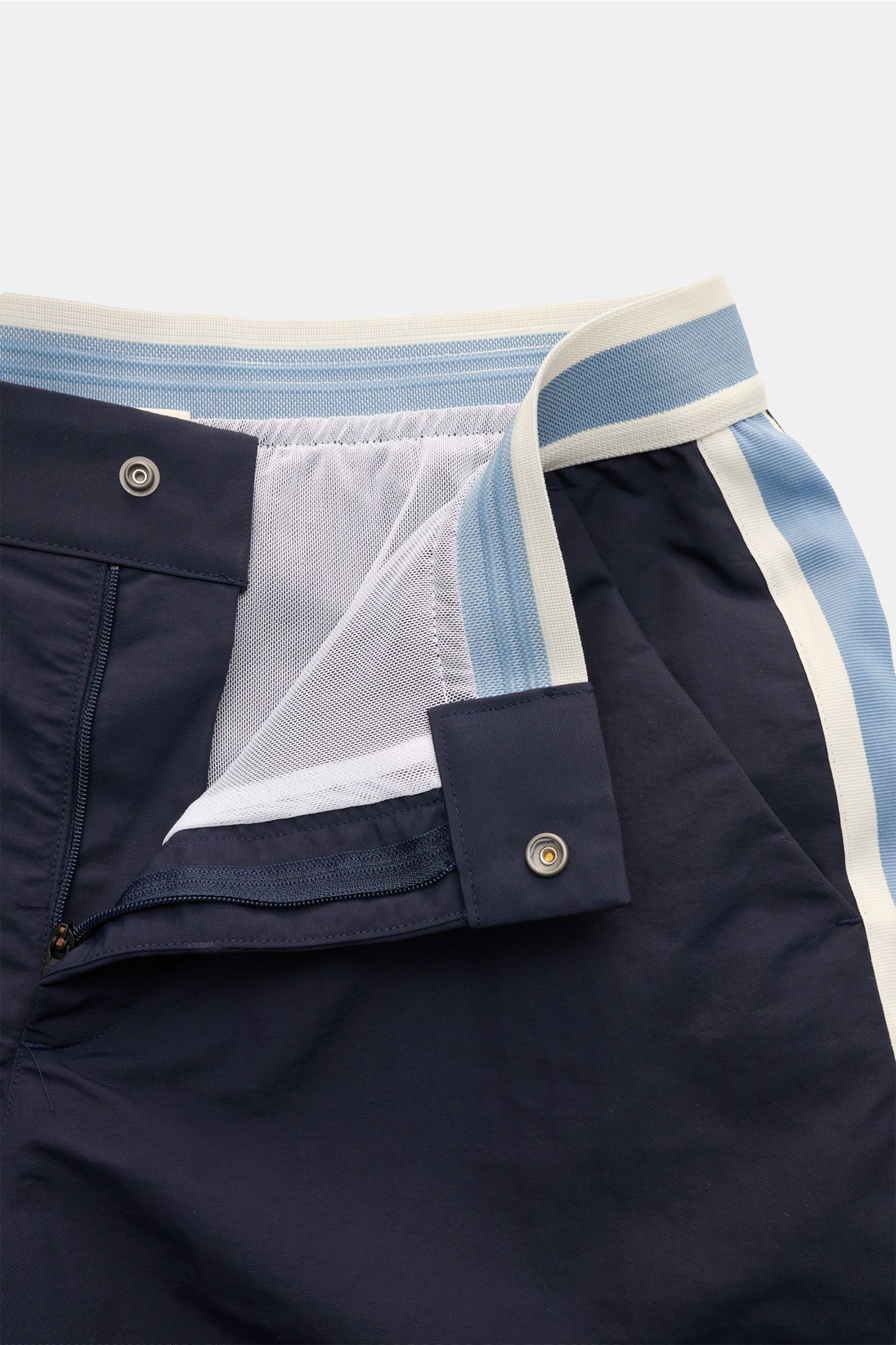 Close-up front view of Ché Swim shorts 'Baller' navy showing elastic waistband, zip, snap button, and mesh lining details.

The swim shorts 'Baller' by CHÉ give summery vibes and have a short cut in a retro design that makes them a must-have for the co