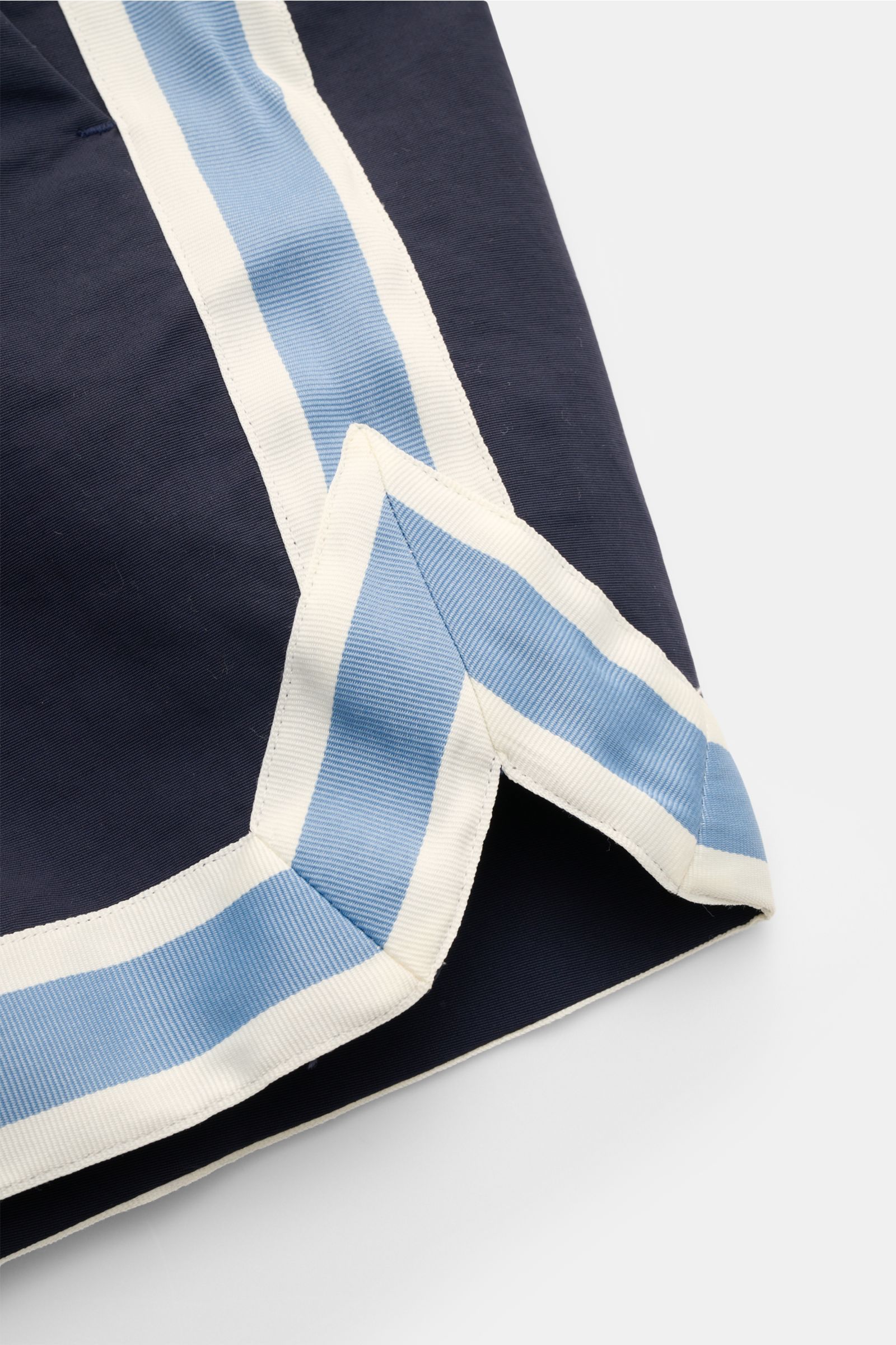 Alt tag (125 characters max): Close-up side view of Ché Swim shorts 'Baller' navy with light blue and white grosgrain trim in retro style.

The swim shorts 'Baller' by CHÉ give summery vibes and have a short cut in a retro design that makes them a must