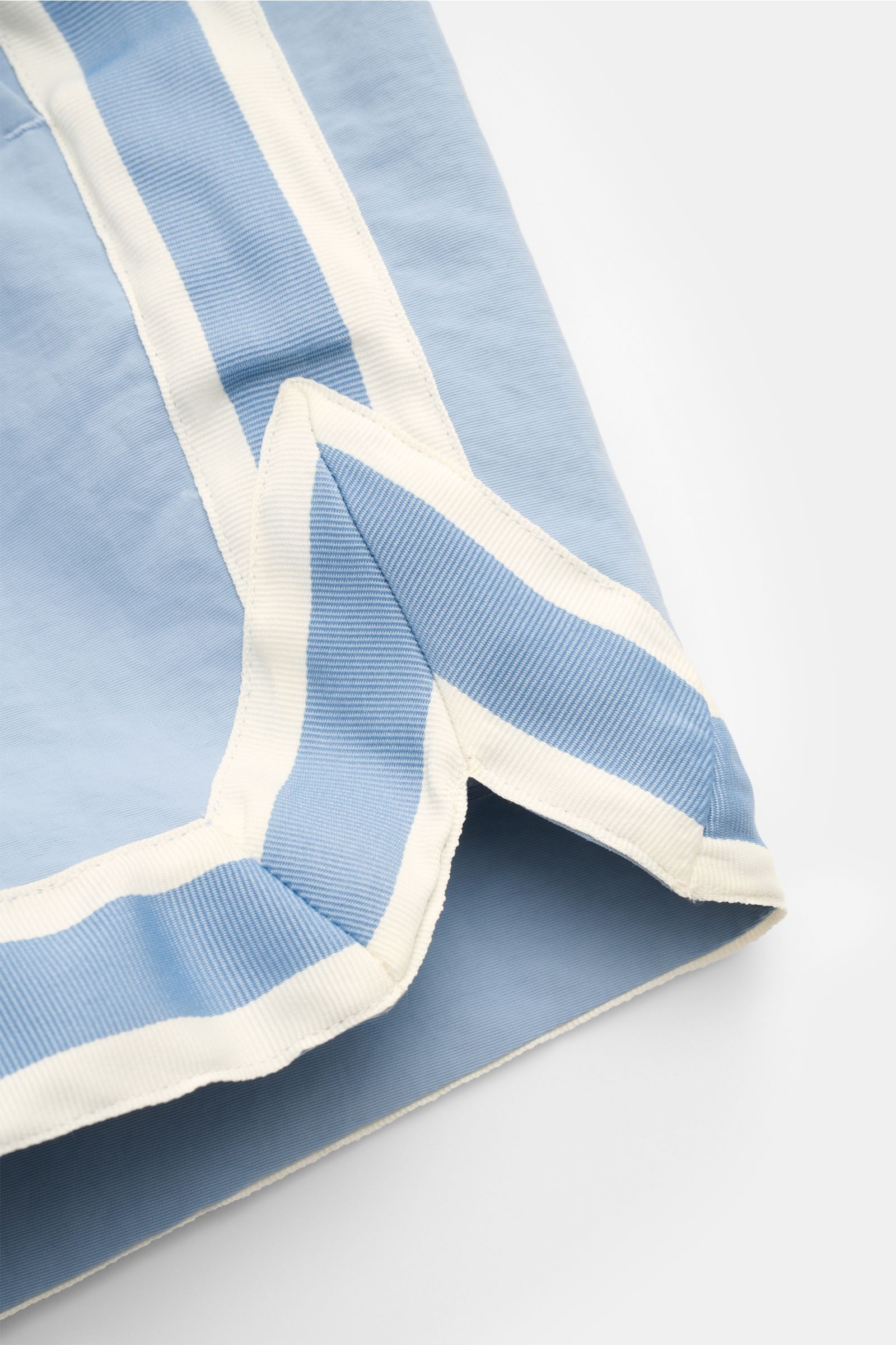 Nahaufnahme der Ché Badeshorts 'Baller' rauchblau mit weiß-blauem Grosgrain-Besatz, kurz, Regular Fit, glatter Microfaser, von unten fotografiert.