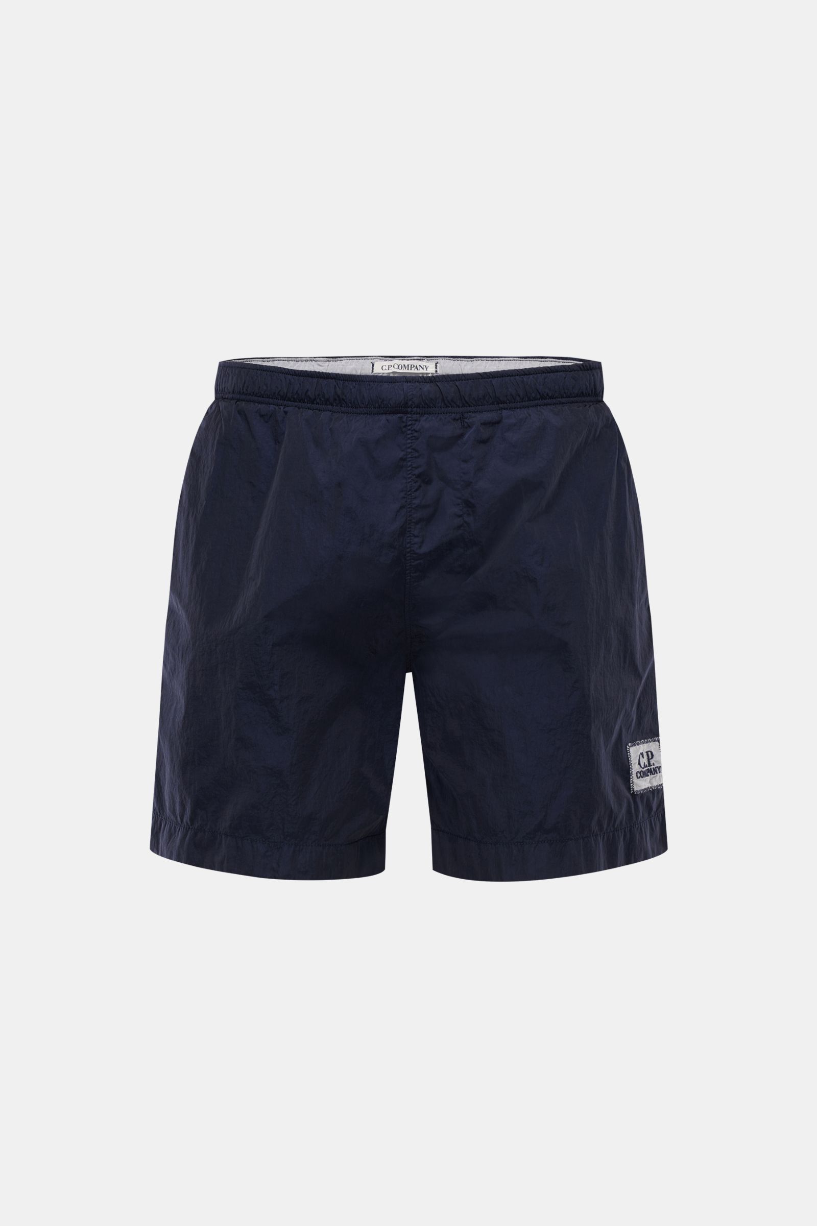 C.P. Company Badeshorts navy in Frontansicht, glänzend, elastischer Bund, schnell trocknende Microfaser, Logo-Patch, Regular Fit, Mesh-Innenfutter, französische Taschen.