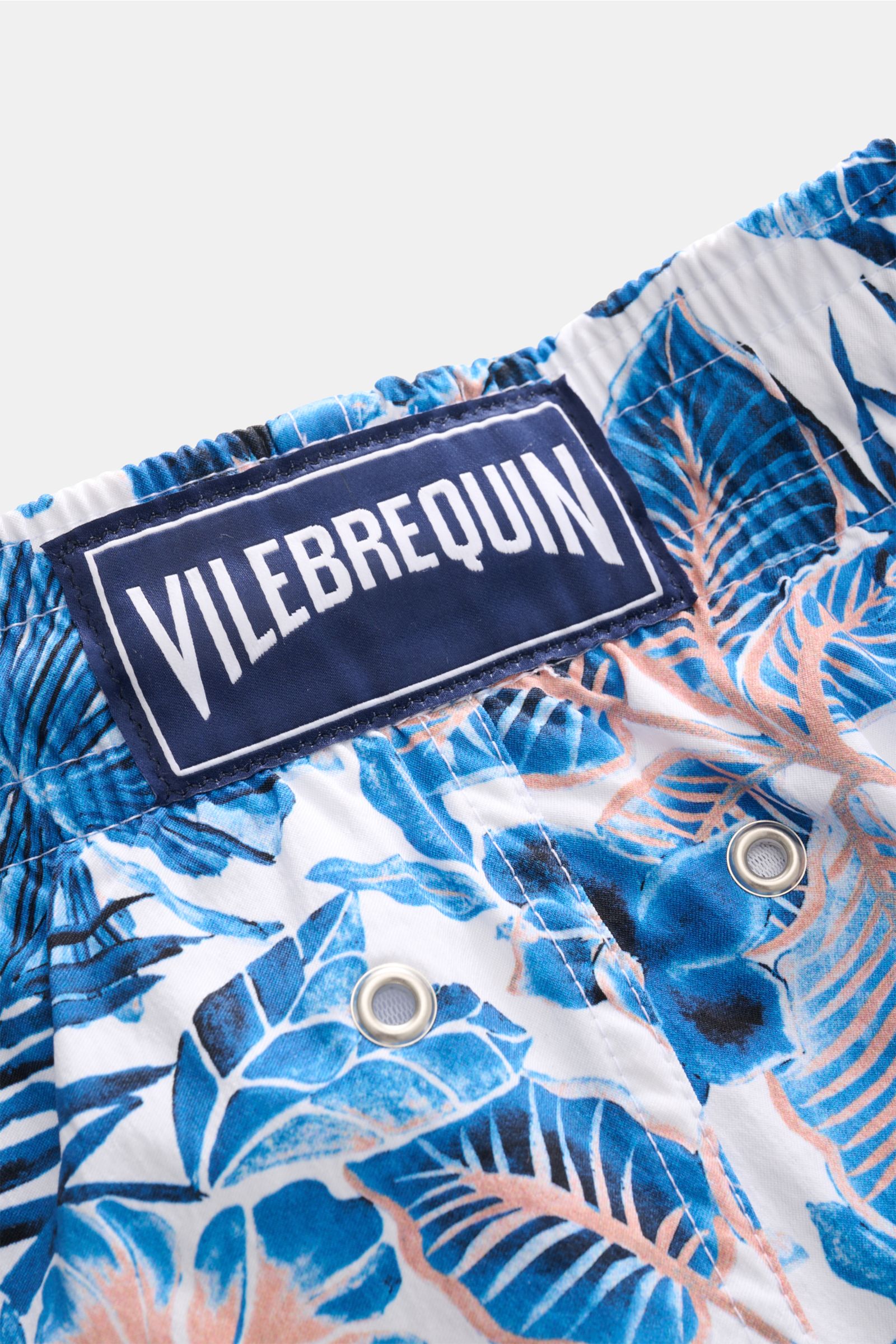Nahaufnahme der elastischen Bund- und Mesh-Innenfutter-Details der Vilebrequin Badeshorts 'Moorise' dunkelblau/weiß gemustert mit floralen Dschungel-Print aus hochwertiger Microfaser, fotografiert aus seitlicher Perspektive.
