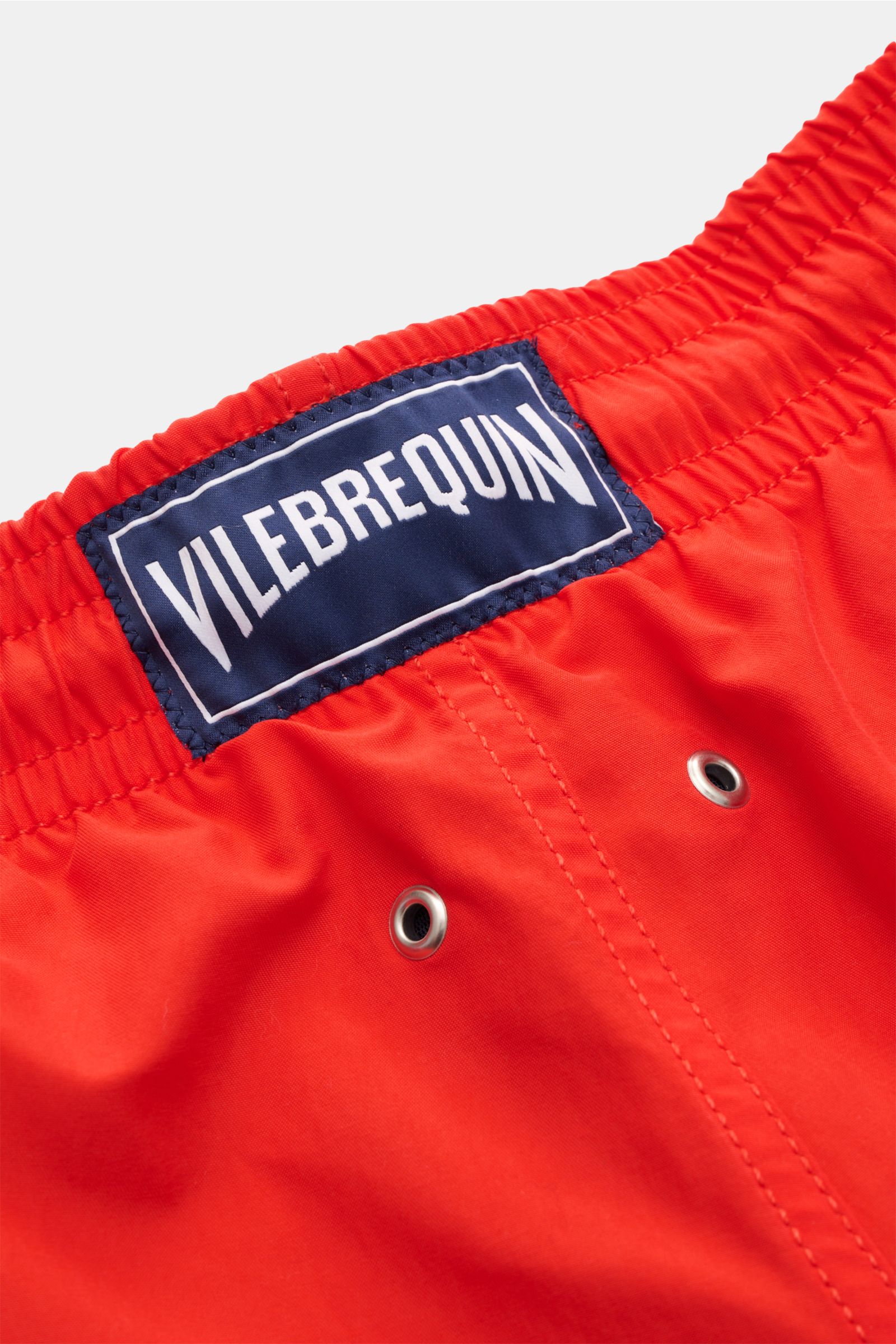 Nahaufnahme der elastischen Bundpartie der Vilebrequin Badeshorts 'Moorea' rot aus hochwertiger Microfaser mit VILEBREQUIN-Weblabel.