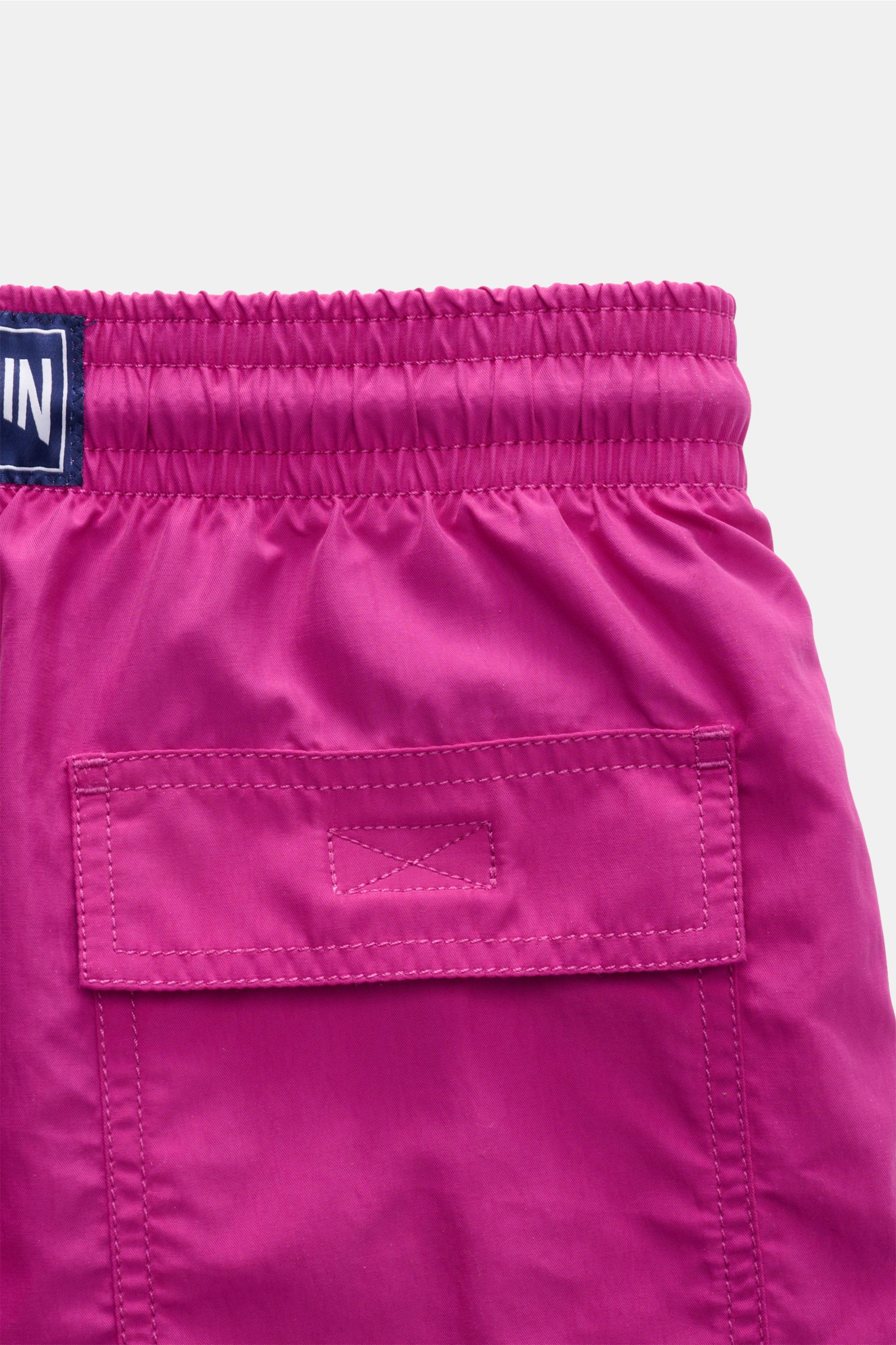 Vilebrequin Badeshorts 'Moorea' violett shown from a close-up rear view, highlighting the elastic waistband, back pocket with flap, and VILEBREQUIN label. Sommer, Sonne, Freiheit: Die Badeshorts 'Moorea' von VILEBREQUIN begleiten Sie stilvoll durch lange 