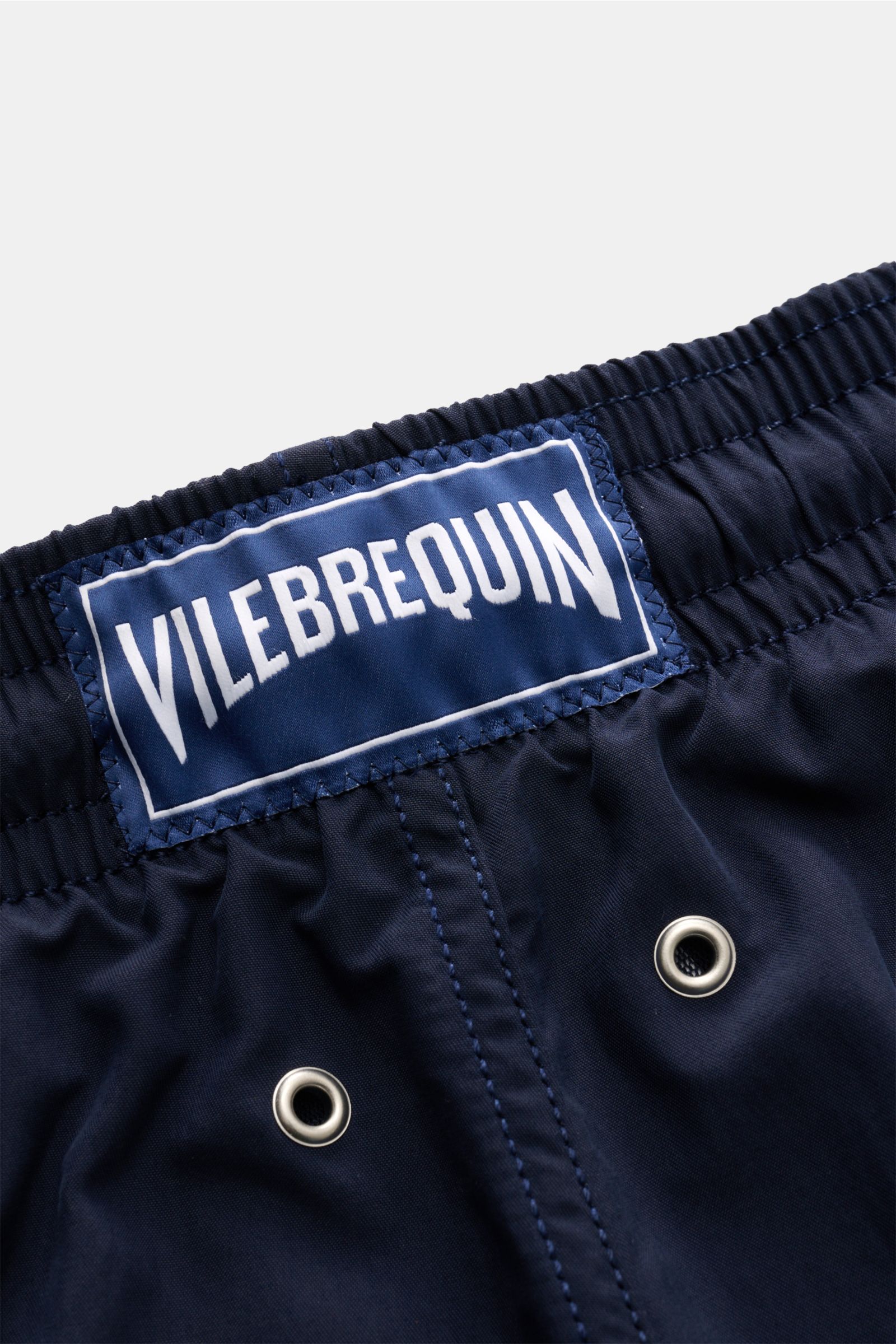Vilebrequin Badeshorts 'Moorea' navy mit VILEBREQUIN-Weblabel, elastischem Bund, Entwässerungsösen aus hochwertiger Microfaser, Detail nah.