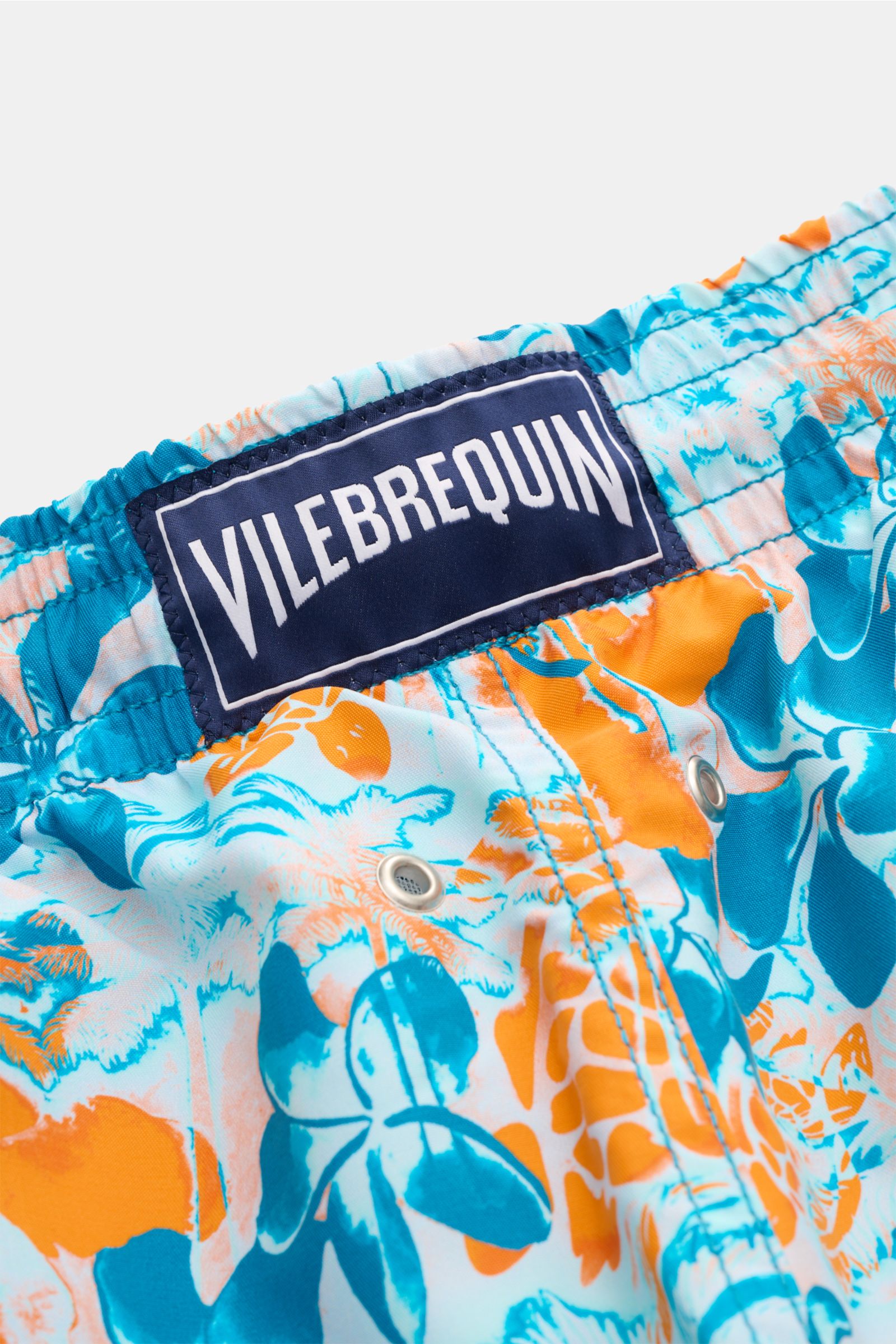 Nahaufnahme aus leichter Schräge der Vilebrequin Badeshorts 'Moorea' blau/neonorange gemustert aus hochwertiger Microfaser mit VILEBREQUIN-Weblabel.