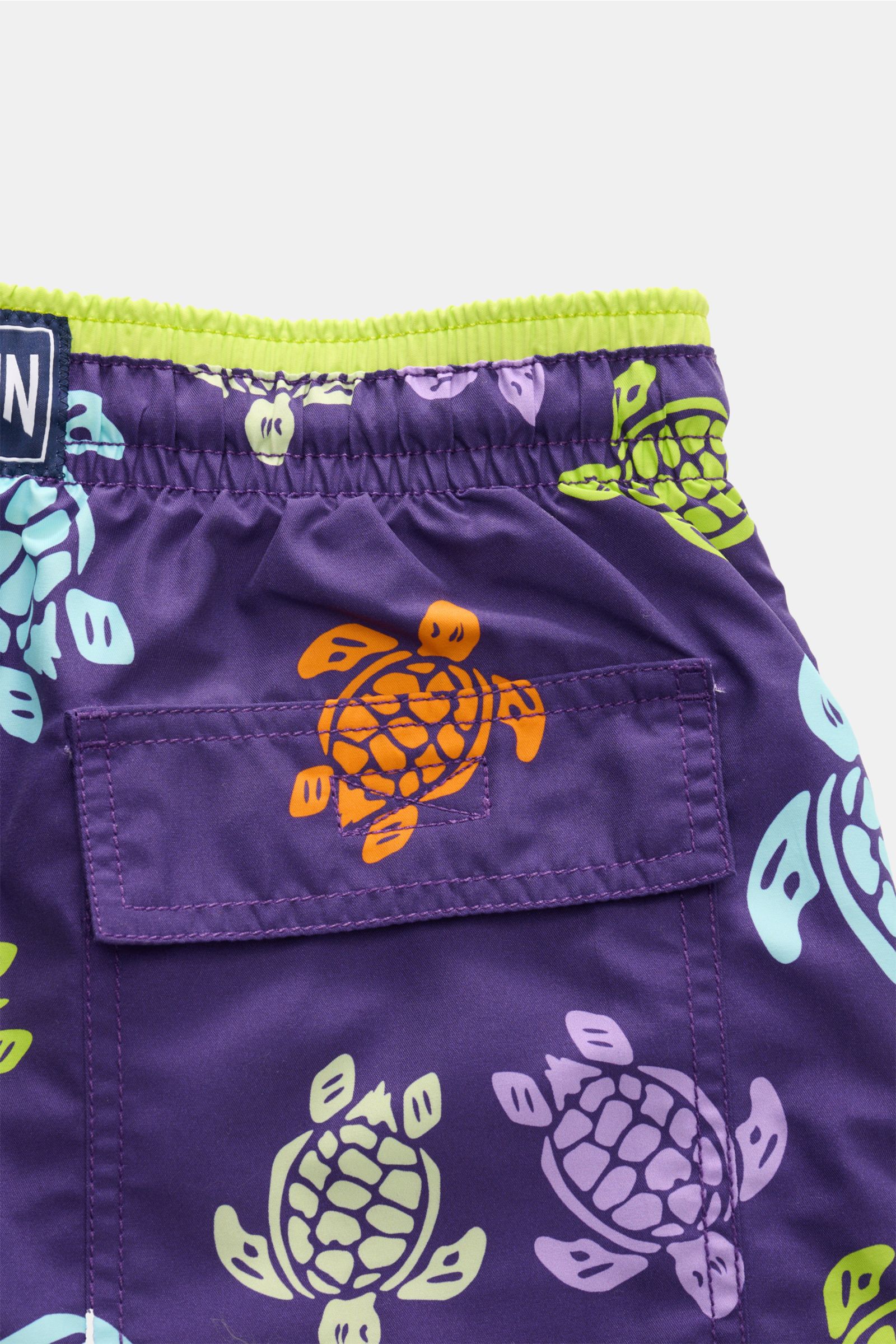 Close-up rear view of Vilebrequin Swim shorts 'Moka' purple/multi-coloured patterned showing elasticated waistband, back pocket with orange turtle print.