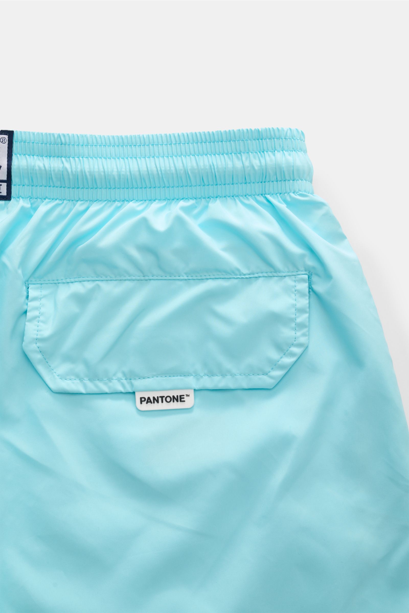 Detailaufnahme der Rückseite der MC2 Saint Barth Badeshorts 'Lightning Pantone' türkis mit elastischem Bund, Tasche und Pantone-Label.

Beschreibung: Das Bild zeigt aus der Nahaufnahme die Rückseite der MC2 Saint Barth Badeshorts 'Lightning Pantone' türki