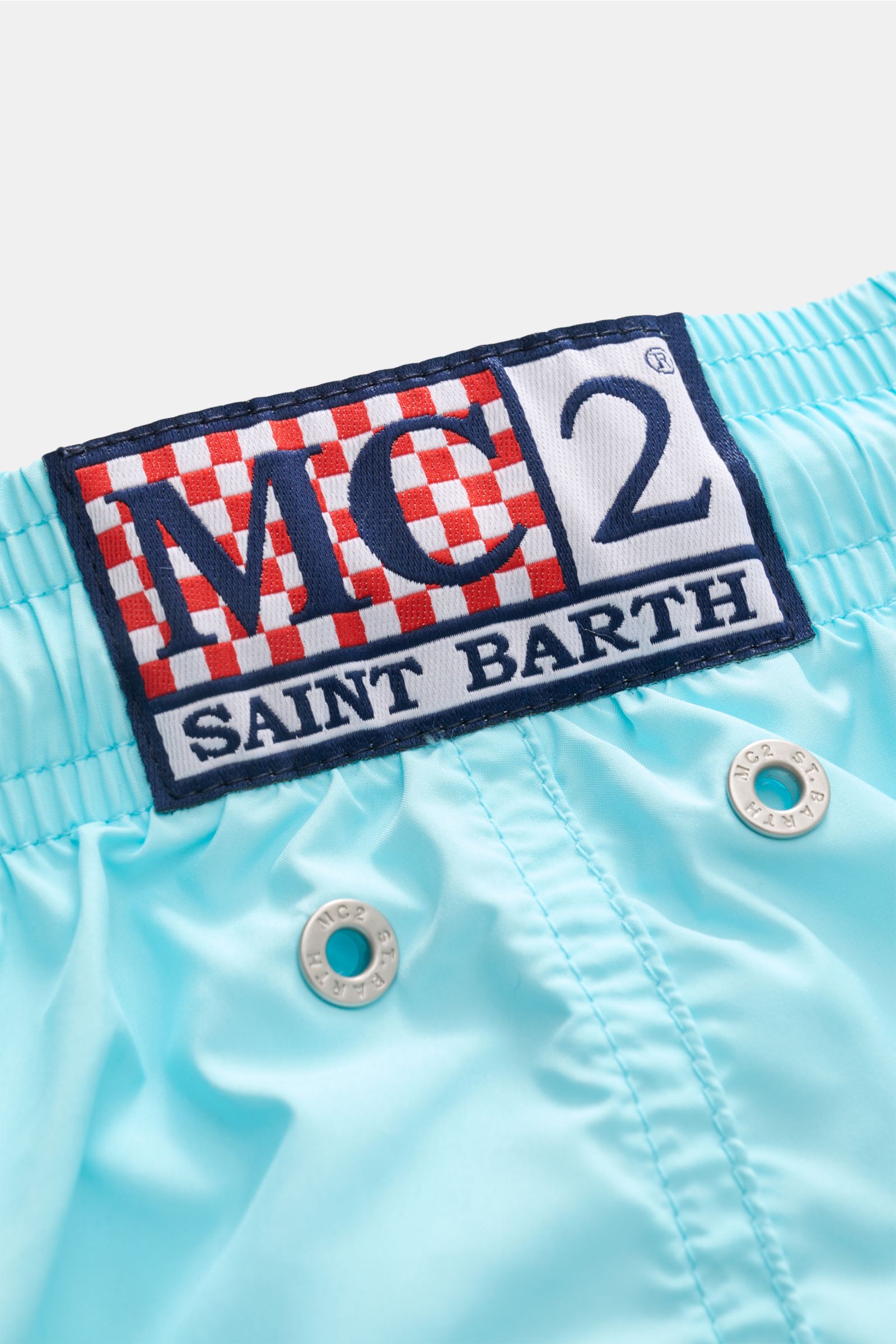 Nahaufnahme der MC2 Saint Barth Badeshorts 'Lightning Pantone' türkis, Fokus auf Logo und Metallösen, leichte Microfaser.